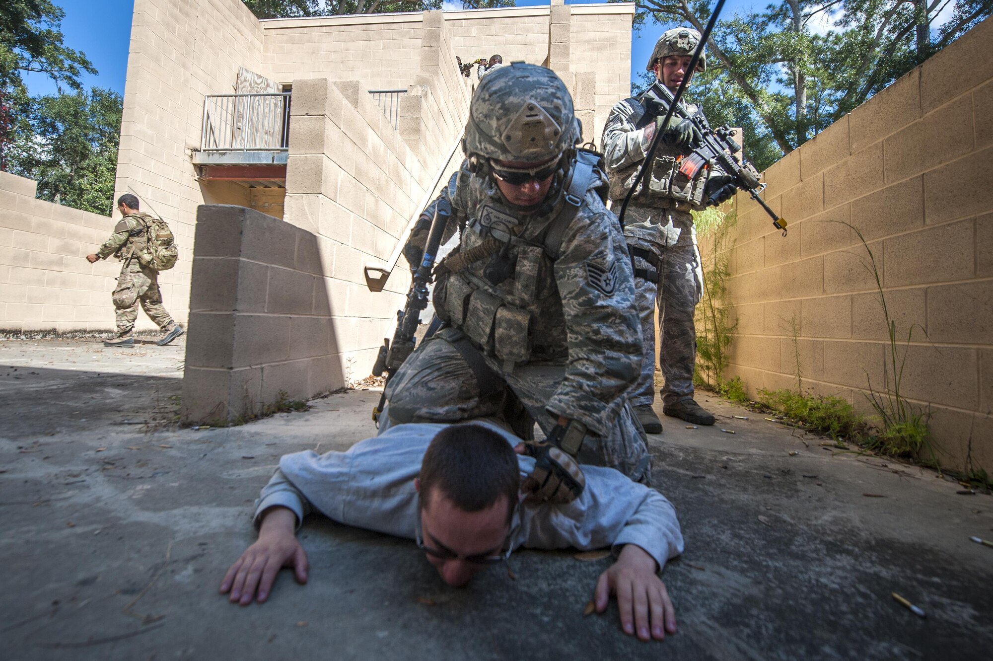 Staff Sgt. Pablo Cancel apprehends a suspect during Exercise Global Eagle Oct. 17, 2013, at Moody Air Force Base, Ga. For the scenario, participants had to recognize and observe villagers moving a suspicious package and respond accordingly. Cancel is assigned to the 822nd Base Defense Squadron.