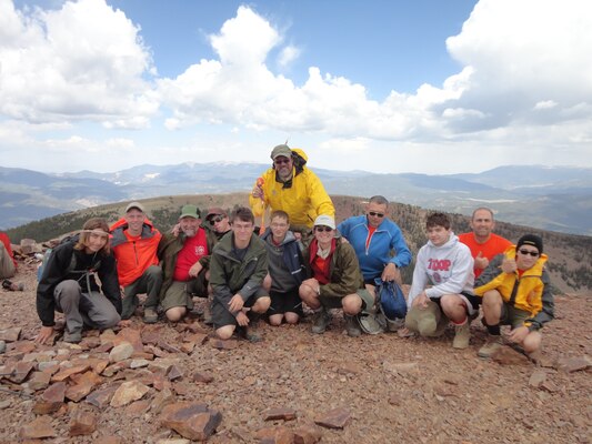 USACE Park Ranger David Quebedeaux (back, dressed in yellow) and his Boy Scout troop pose with their rubber chicken for a picture on the summit of Baldy Mountain (12,441 feet) in northern New Mexico during their hike at the Philmont Scout Ranch, June 17, 2013. Quebedeaux uses rubber chickens as a fun motivator while the Scouts hike difficult, steep trails in cold weather conditions. The troop packed multiple rubber chickens and gave them out to people they met on the trail who made a positive impression on their group. "Nobody can resist smiling when they are holding their very own rubber chicken," Quebedeaux said.