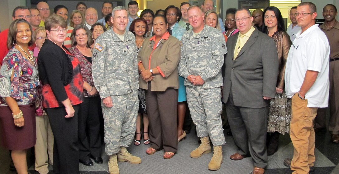 From left, Huntsville Center deputy commander Lt. Col. William Burruss, Huntsville Center Equal Opportunity Employment Office chief Angela Morton and commander Col. Robert Ruch wear purple ribbons with Huntsville Center employees to raise awareness about domestic violence.