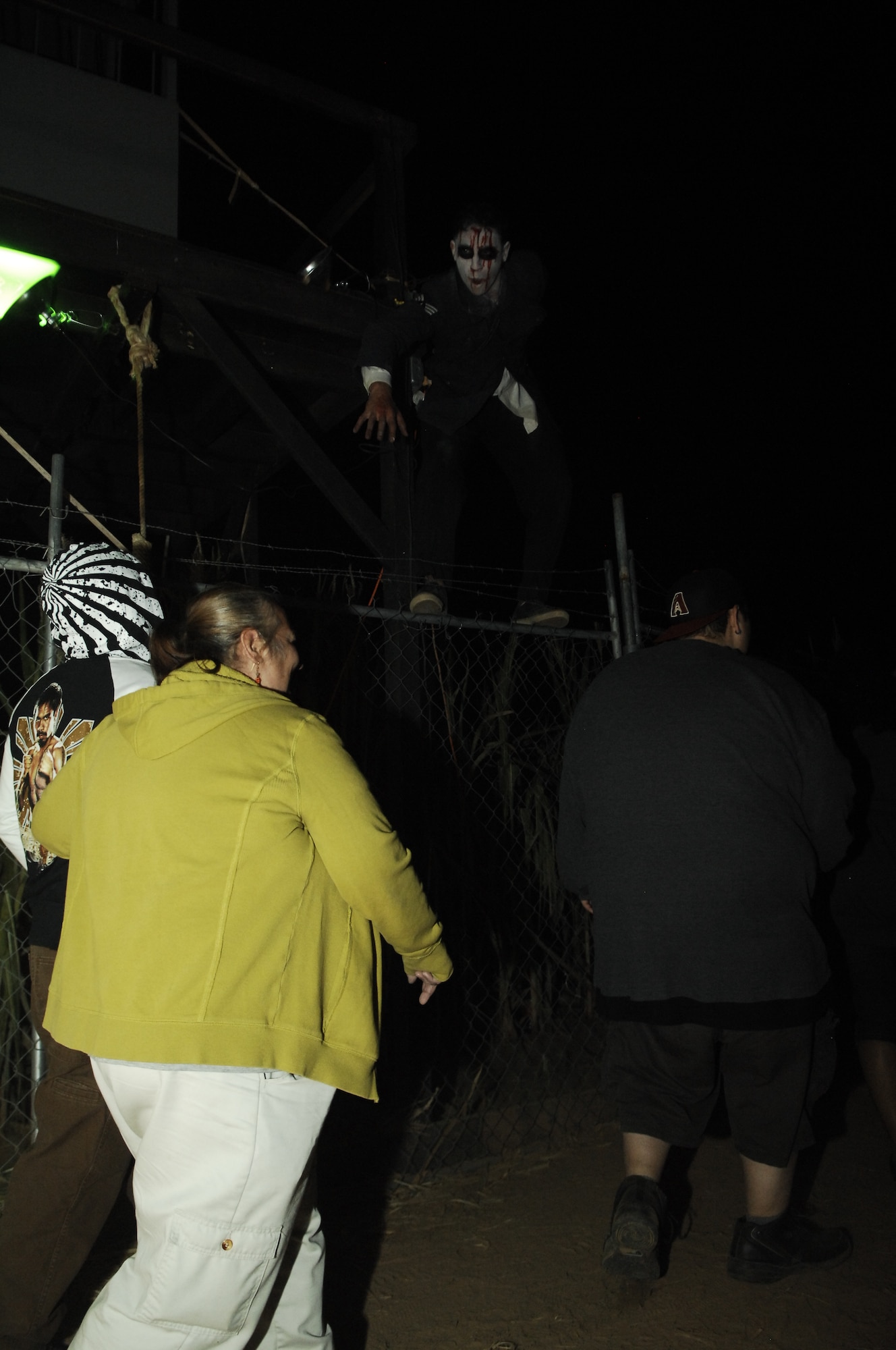 Senior Airman Joshua Cede?o, 355th Comptroller Squadron customer service technician, frightens a group of people during Buckelew Farm's "Terror in the Corn" Oct. 25, 2013. Airmen volunteered from Davis-Monthan Air Force Base, Ariz. to help the farm by dressing up in costumes, providing security, and helping with make-up and moving props.(U.S. Air Force Photo by Senior Airman Camilla Elizeu/Released)