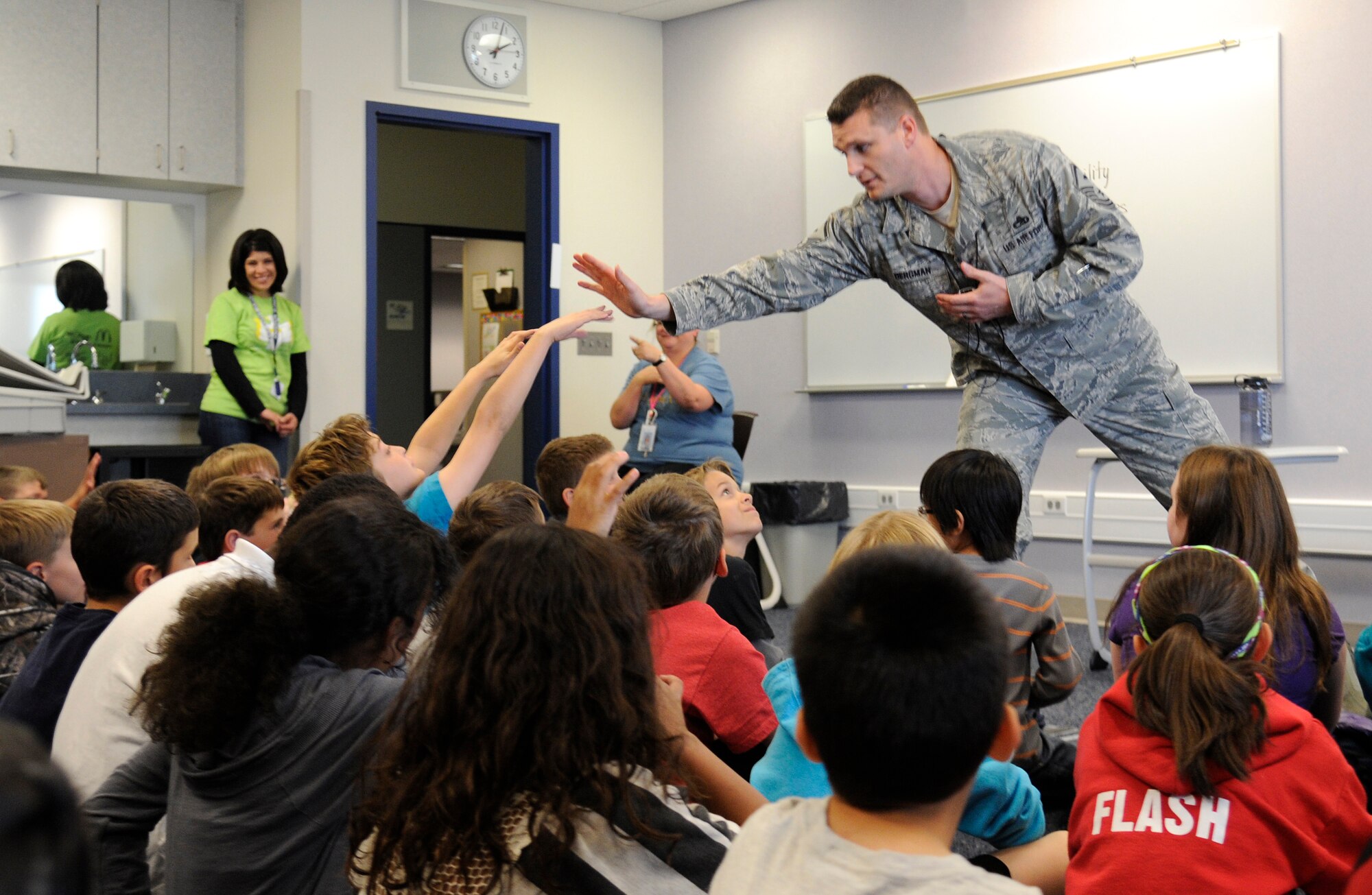 Master Sgt. Shawn Bergman, 66th Training Squadron first sergeant, gives Michael Anderson Elementary School students a high five while talking about National Disability Employment Awareness Month at Fairchild Air Force Base, Wash., Oct. 25, 2013. (U.S. Air Force photo by Airman 1st Class Ryan Zeski/Released)