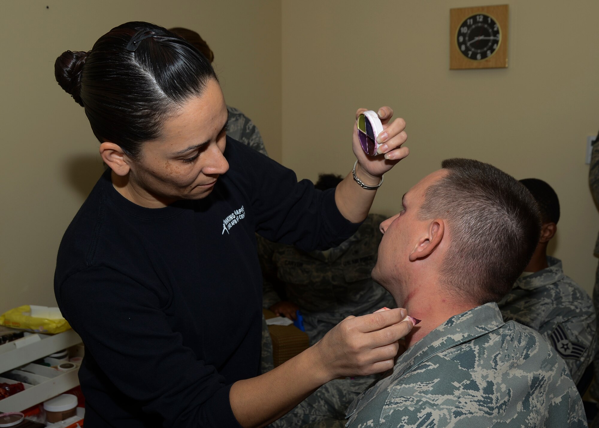 Master Sgt. Justin Jerome (right), 411th Flight Test Squadron, volunteered to have Master Sgt. Valerie Vasquez, 412th Medical Group, create scratch marks on his neck to show that men are victims of domestic violence too. (U.S. Air Force photo by Rebecca Amber)