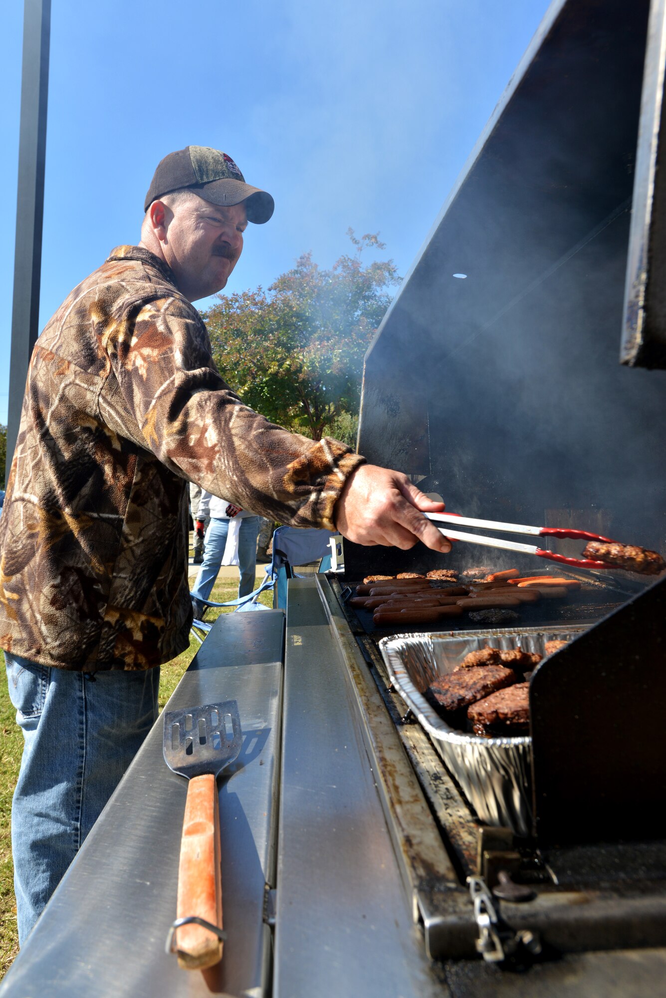 U.S. Air Force Master Sgt. Eric Schmitt, 20th Civil Engineering Squadron NCO in charge, cooks burgers and hot dogs during the 14th Annual Ability One Appreciation Picnic, Shaw Air Force Base S.C., Oct. 25, 2013. The annual picnic, hosted by the 20th Contracting Squadron, provided free food for nearly 175 Ability One employees and family members as a way of thanking them for their support to Team Shaw. (U.S. Air Force photo by Airman 1st Class Jensen Stidham/Released)