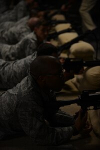 U.S. Air Force Airmen from the 633rd Logistics Readiness Squadron prepare to fire during a simulated live-fire training session at Fort Eustis, Va., Oct. 28, 2013. The annual training is part of a new hands-on program for 633rd LRS Airmen, offering combat training in a controlled environment. (U.S. Air Force photo by Staff Sgt. Ciara Wymbs/Released)
