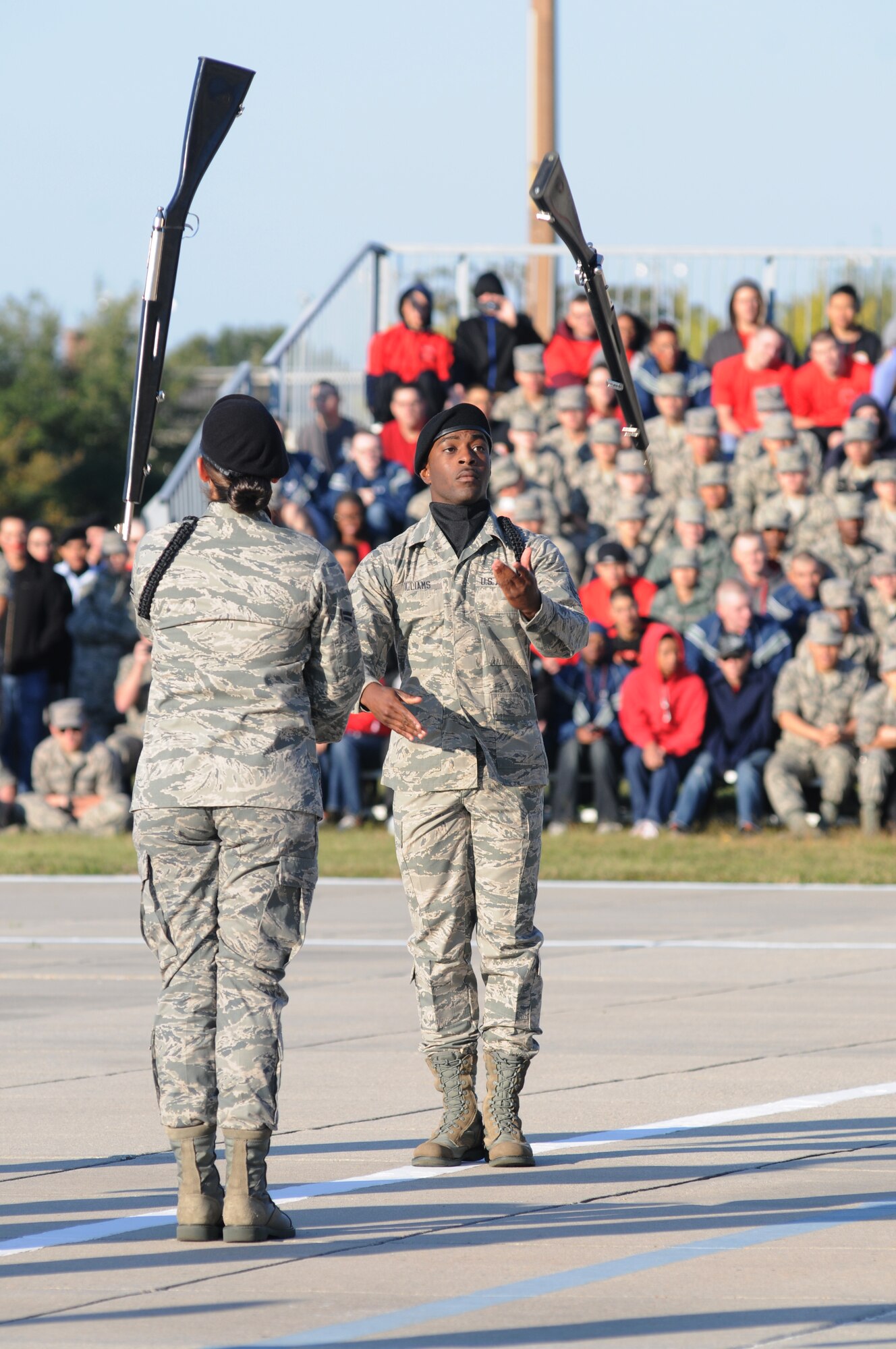 Airman 1st Class Solomen Williams, 338th Training Squadron, spins rifles with a team member during the 81st Training Group drill down competition Oct. 25, 2013, at the Levitow Training Support Facility, Keesler Air Force Base, Miss.  The 338th TRS was the overall winner of the drill down and placed first in the open ranks and regulation competition.  (U.S. Air Force photo by Kemberly Groue)