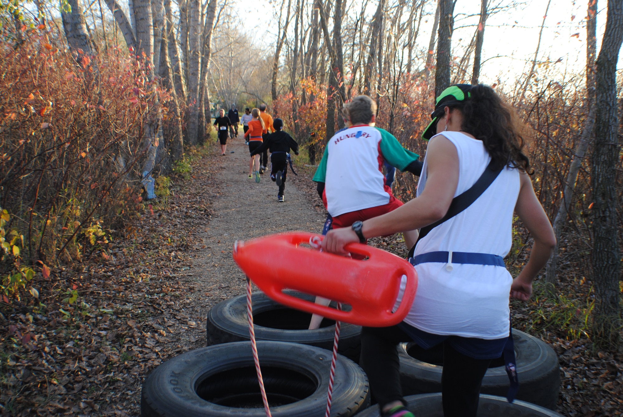 Competitors navigate their way through a tire obstacle during the Zombie Run hosted by the Air Force Sergeants Association, Chapter 964, Oct. 26, 2013, on Grand Forks Air Force Base, N.D. The obstacles located along the three and five-kilometer trails provided a physically challenging and fun-filled event for Airmen and their families. (U.S. Air Force photo/Staff Sgt. Luis Loza Gutierrez)