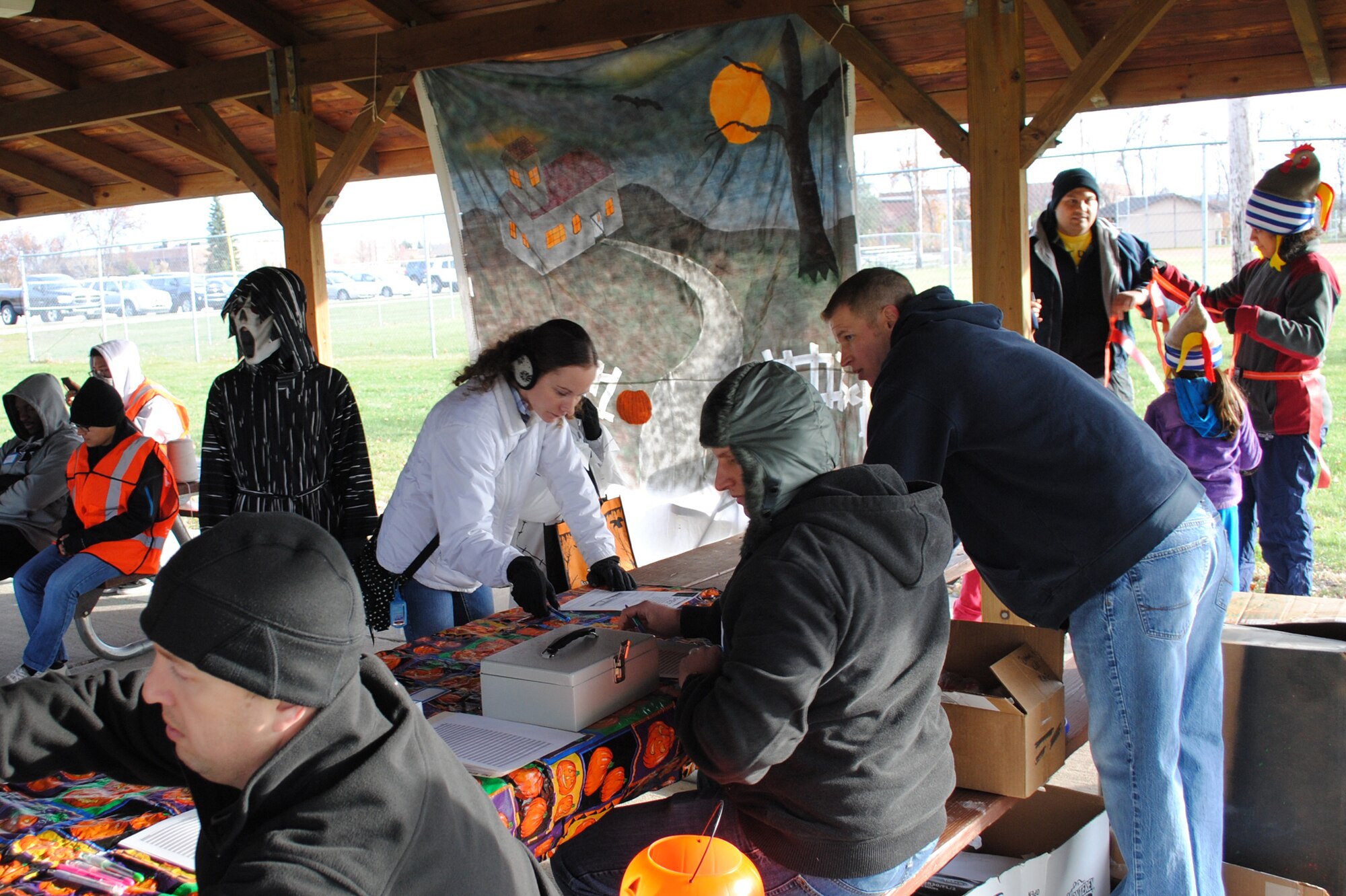 Air Force spouse Geneva Madnick (center), registers herself and her two sons, Trenton and Austin, for the family fun run portion of the Zombie Run, which took place Oct. 26, 2013, on Grand Forks Air Force Base, N.D. More than 60 participants outran and dodged volunteers disguised as zombies along the three and five-kilometer runs of the event hosted by the Air Force Sergeants Association, Chapter 964. (U.S. Air Force photo/Staff Sgt. Luis Loza Gutierrez)