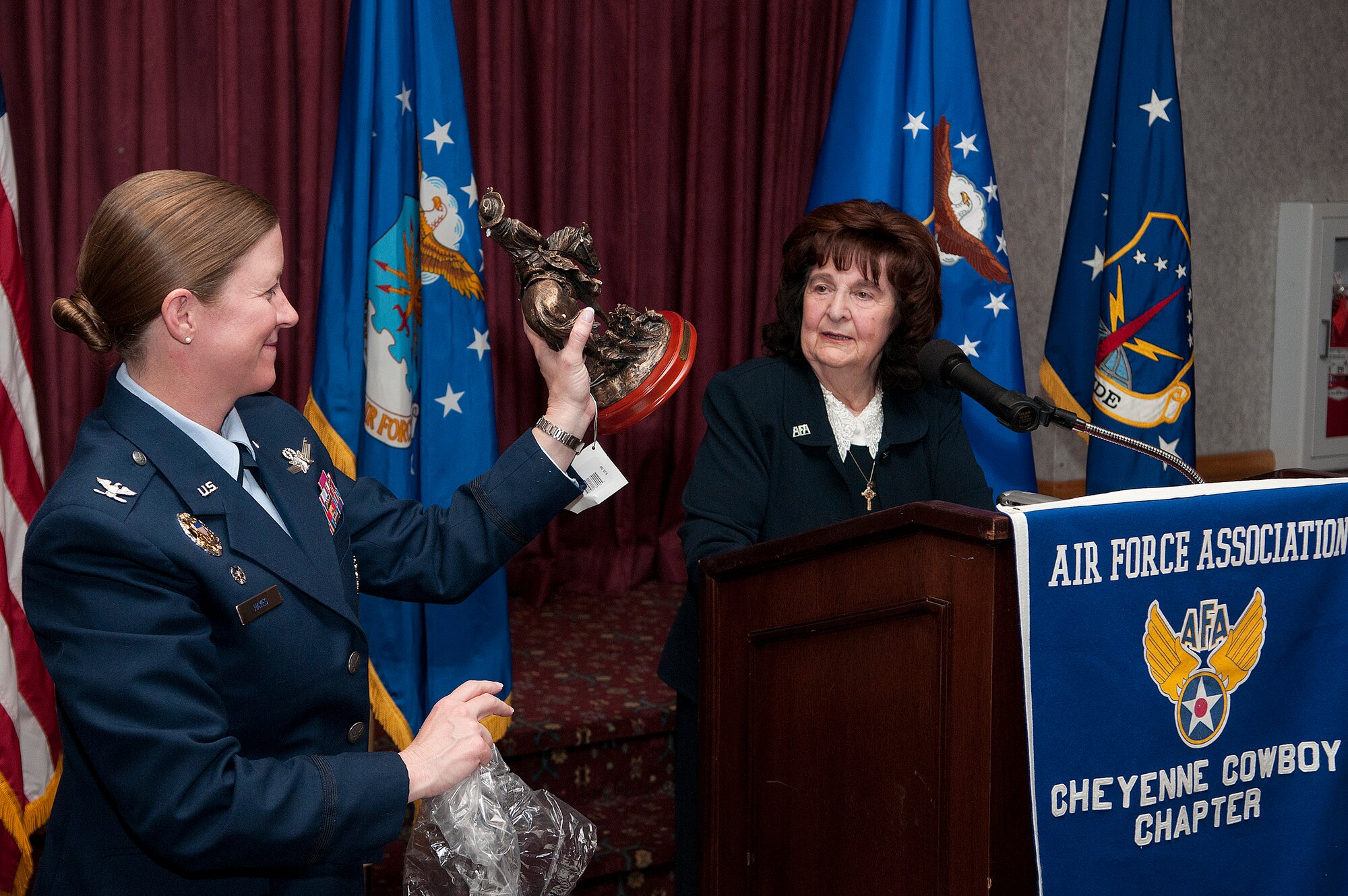 Col. Tracey Hayes, 90th Missile Wing commander, holds up a statue presented by Irene Johnigan, Air Force Association Cheyenne Cowboy Chapter 357 president, in appreciation of Hayes being the keynote speaker for the 66th annual AFA banquet held in the Trail’s End Club, F.E. Warren Air Force Base, Wyo., Oct. 24, 2013. According to its website, the AFA is a non-profit, independent association promoting the United States Air Force honoring Airmen and supporting the total Air Force family. (U.S. Air Force photo by R.J. Oriez)