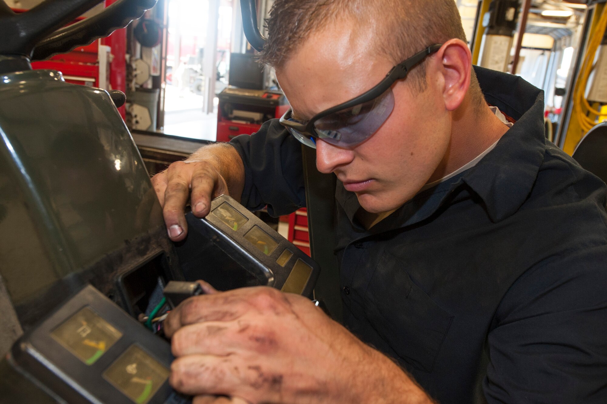 U.S. Air Force Staff Sgt. Tyler Craig, 23d Logistics Readiness Squadron mechanical analyst technician journeyman, detaches a government forklift dashboard at Moody Air Force Base, Ga., Oct. 28, 2013. Craig detected excessive wiring corrosion, which caused malfunctions with the dashboard. (U.S. Air Force photo by Airman Dillian Bamman/Released)