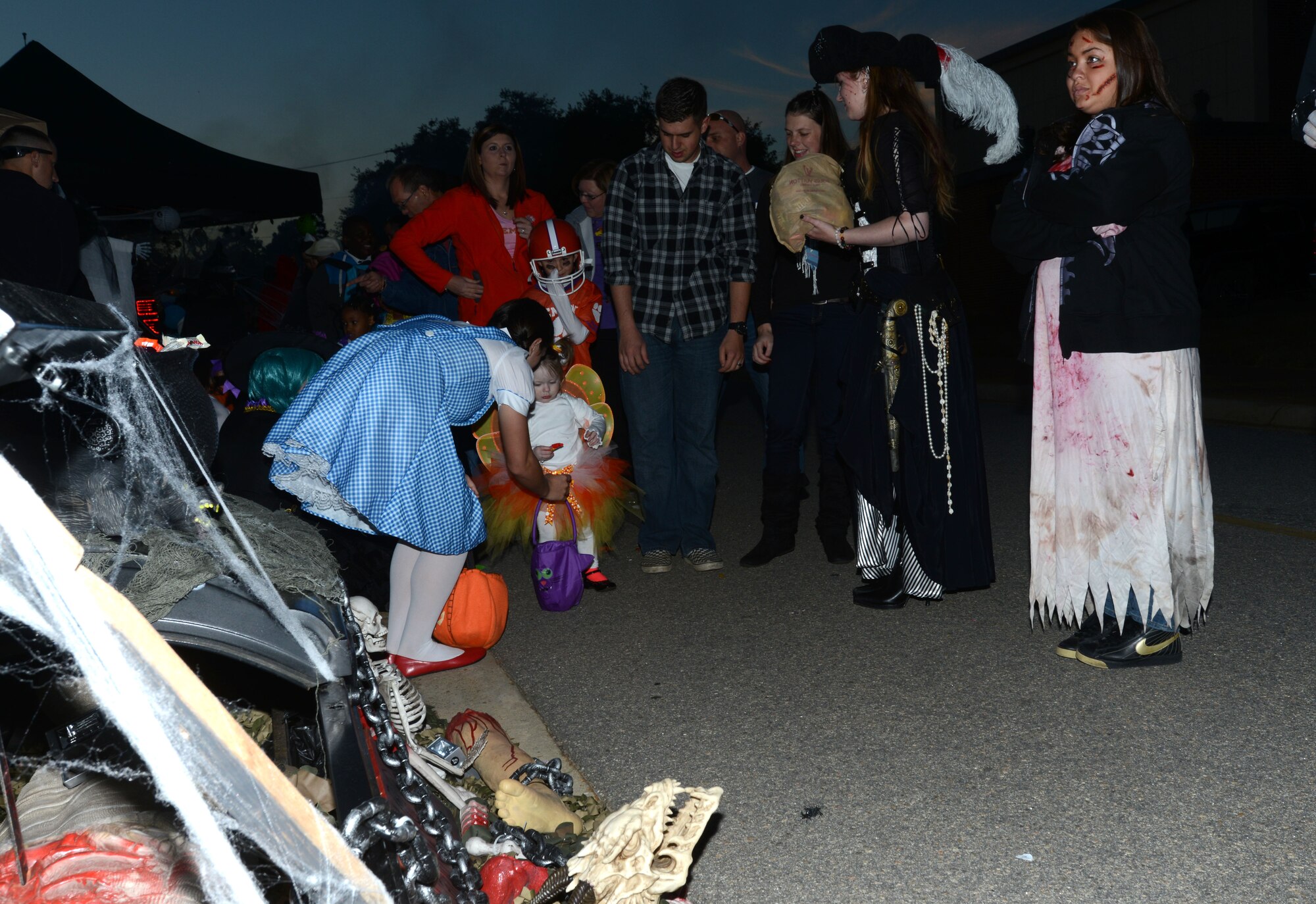 A volunteer at the Air Force Sergeants Association trunk passes out candy during the Boo Bash and Trunk-or-Treat event Oct. 26, 2013, at Shaw Air Force Base, S.C. AFSA placed third in the events trunk decorating contest. This annual event is hosted to provide a safe Halloween experience for Team Shaw families. (U.S. Air Force photo by Senior Airman Laura L. Valentine/Released)