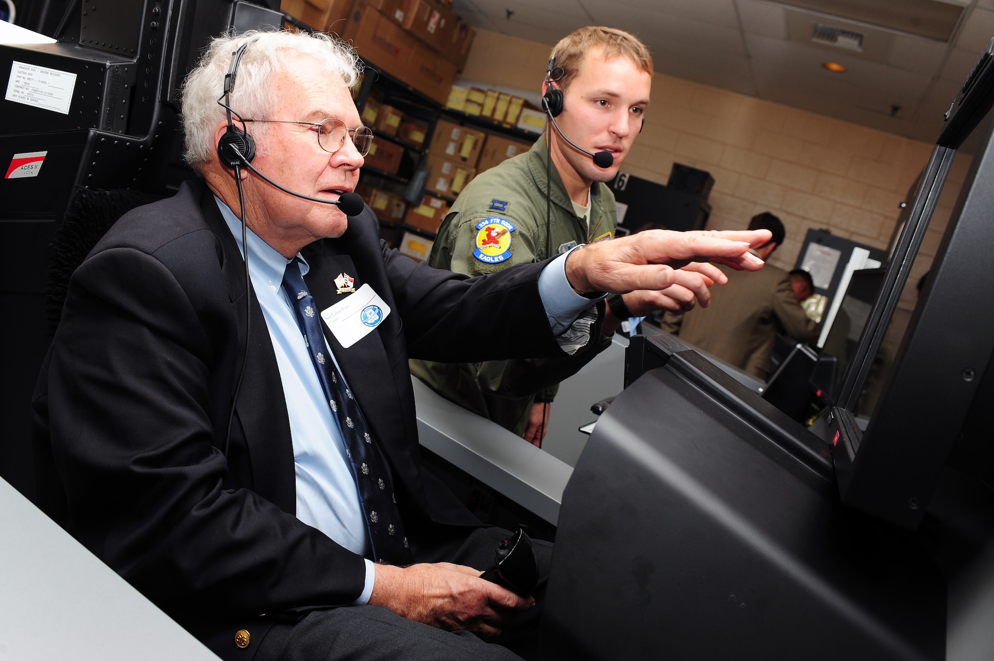 U.S. Air Force Capt. Adam Luber, 334th Fighter Squadron pilot, assists North Carolina Sen. Louis Pate with flight simulator procedures during a tour at Seymour Johnson Air Force Base, N.C., Oct. 24, 2013. Members of the North Carolina State Legislature experienced how aircrew operate when flying in an F-15E Strike Eagle aircraft. (U.S. Air Force photo by Airman 1st Class John Nieves Camacho)