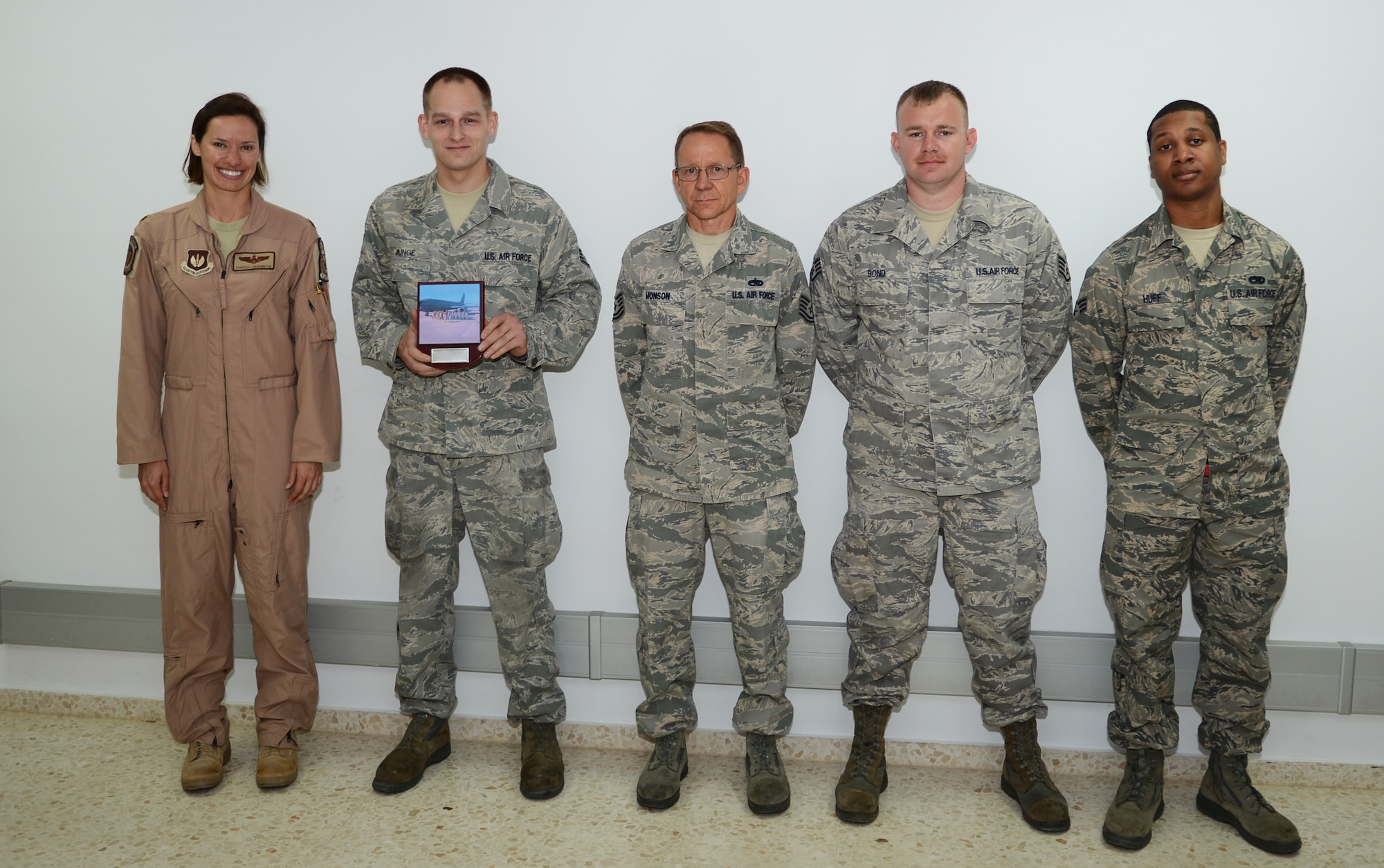 U.S. Air Force Maj. Charissa Cherrington, left, 351st Expeditionary Air Refueling Squadron commander, poses with members of the maintenance crew for a KC-135 Stratotanker, tail number 63-8027, assigned to RAF Mildenhall but forward-deployed in support of contingency operations Oct. 22, 2013, at Moron Air Base, Spain. The crew received a Spanish tile with a screen printed image of 351st EARS personnel and their aircraft for achieving zero discrepancies, making it a black-letter aircraft. The tile will be mounted in the aircraft as a reminder of the maintenance crew’s achievement. (U.S. Air Force photo by Airman 1st Class Dillon Johnston/Released)