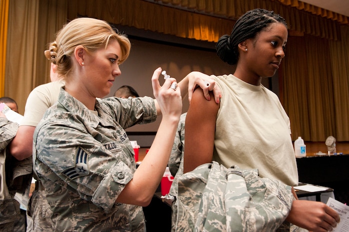 Senior Airman Jennifer Pontillo, 99th Medical Operations Squadron medical technician, administers the annual flu vaccine to Airman 1st Class Amber Philips, 57th Maintenance Squadron knowledge operator, at the base theater Oct. 25, 2013, at Nellis Air Force Base, Nev. The base theater served as a point of distribution for the vaccine allowing the 99th MDOS to vaccinate as many active-duty Airmen as possible in a short amount of time. (U.S. Air Force photo by Airman 1st Class Thomas Spangler) 