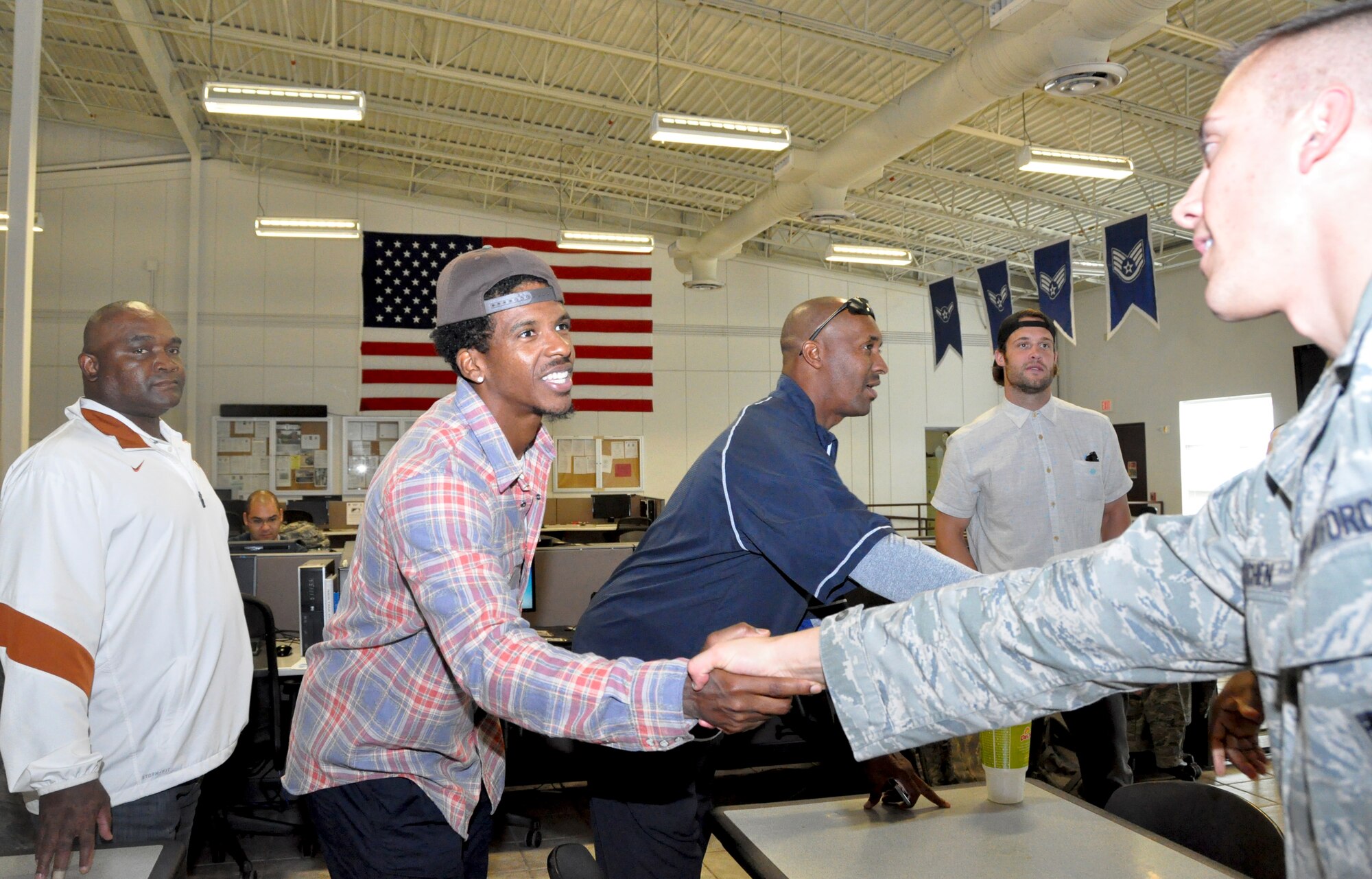 Four former National Football League members took time out to visit with 301st Fighter Wing members Oct. 22 just days before they are to deploy to Southwest Asia. Seen from left to right are James Gray, New England Patriots, Justin King, LA Rams, Byron Williams, NY Giants, and David Vabora, St. Louis Rams, as they shake hands with Capt. Jason Kitchen, 301st Aircraft Maintenance Squadron commander. (U.S. Air Force photo/MSgt. Julie Briden-Garcia) 