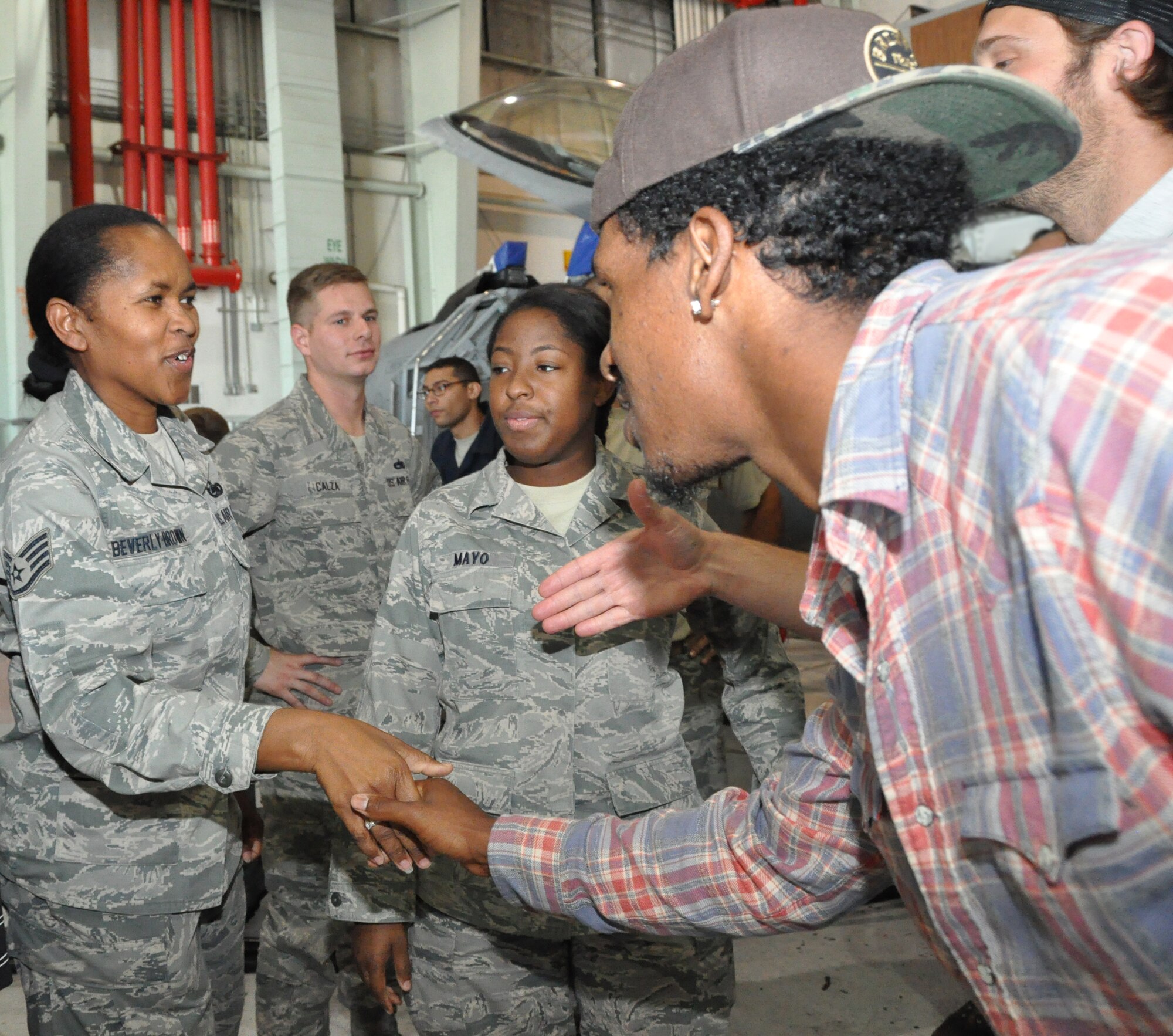 Staff Sgt. Pam Beverly Brown and Senior Airman Keneasha Mayo; both from the 301st Logistics Readiness Squadron, stopped to shake hands with a couple of former National Football League members who came to give their thanks to our military members. Four former NFL members took time out to visit with 301st Fighter Wing members Oct. 22 just days before they are to deploy to Southwest Asia. Seen here are; left to right; Justin King and David Vabora; both from the St. Louis Rams. (U.S. Air Force photo/MSgt. Julie Briden-Garcia)