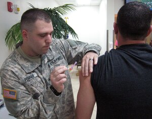 U.S. Army Sgt. Eric Penner administers the flu vaccine to a member of Joint Task Force-Bravo, Soto Cano Air Base, Honduras, Oct. 27, 2013.  Joint Task Force-Bravo's Medical Element (MEDEL) is providing the flu vaccine to all members of the task force in order to prevent the spread of the flu virus.  (U.S. Air Force photo by Capt. Zach Anderson)