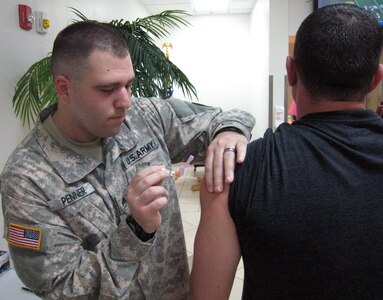 U.S. Army Sgt. Eric Penner administers the flu vaccine to a member of Joint Task Force-Bravo, Soto Cano Air Base, Honduras, Oct. 27, 2013.  Joint Task Force-Bravo's Medical Element (MEDEL) is providing the flu vaccine to all members of the task force in order to prevent the spread of the flu virus.  (U.S. Air Force photo by Capt. Zach Anderson)