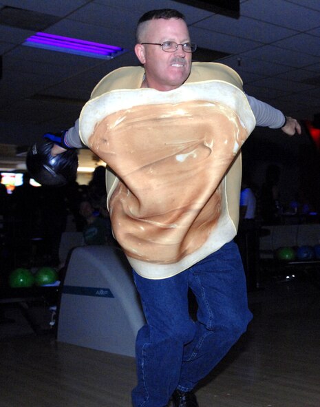 Chief Master Sgt. David Duncan, 319th Air Base Wing command chief master sergeant, bowls as the peanut butter half of a peanut butter and jelly sandwich Oct. 25, 2013, during Monster Bowling at the Dakota Lanes Bowling Alley on Grand Forks Air Force Base, N.D. The event offered family-friendly costume bowling and a costume contest. (U.S. Air Force photo/Staff Sgt. Susan L. Davis)