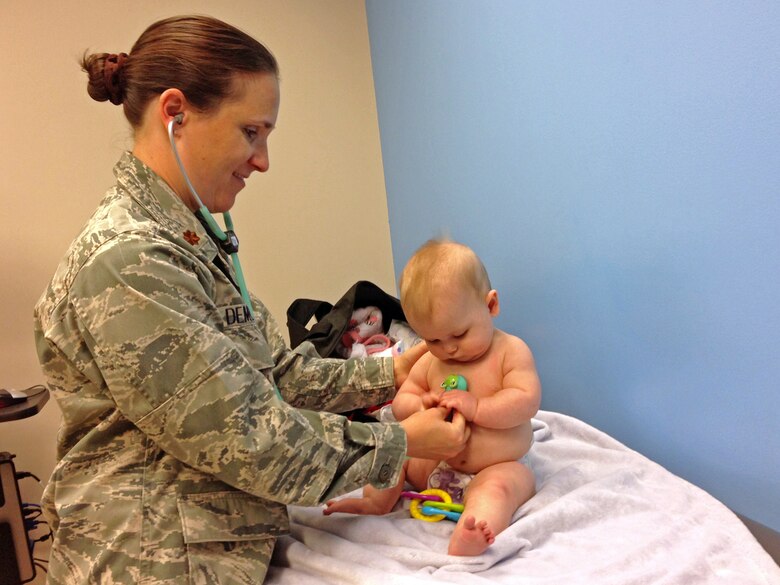 PETERSON AIR FORCE BASE, Colo. – 6-month-old Adolyn looks curiously at the colorful animal on  the end of a stethoscope during an exam performed by Maj. Patti Demotts, 21st Medical Operations Squadron pediatric nurse practitioner. “I can relate, having children of my own, I know what parents are going through when they have been up all night with a sick child,” said Demotts. (Courtesy photo)