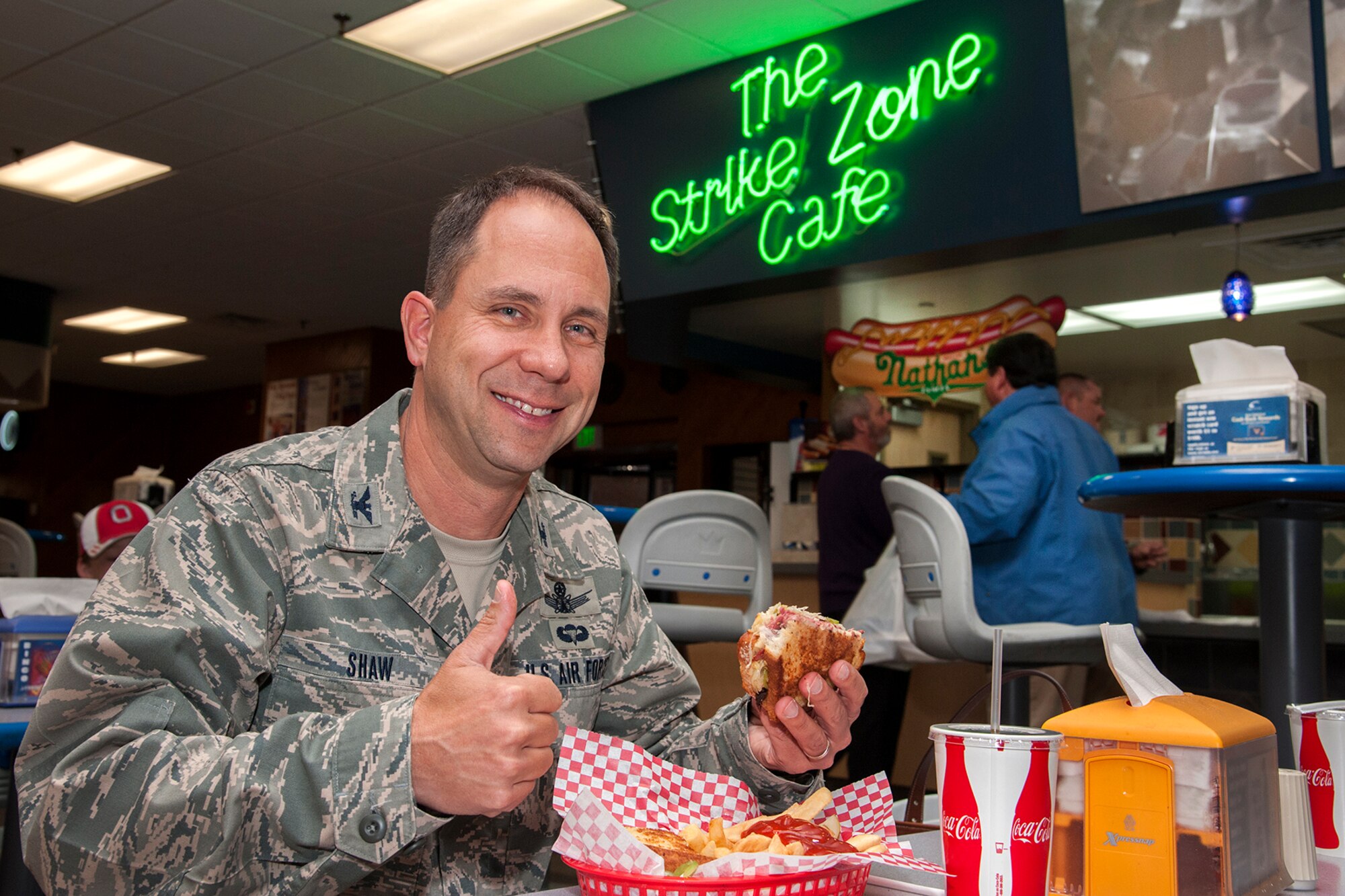 PETERSON AIR FORCE BASE, Colo. – Col. John Shaw, 21st Space Wing commander, gives a thumbs up for the Happy Friday Shaw-strami Sandwich Oct. 24 at the Peterson Bowling Center. The new namesake sandwich is available Fridays in November at The Strike Zone Café, and is based on Shaw’s recipe. The sandwich includes pastrami, Swiss cheese, green peppers and browned sour kraut on grilled sour dough bread. The sandwich also comes with a choice of fries or potato salad. (U.S. Air Force photo/Craig Denton)