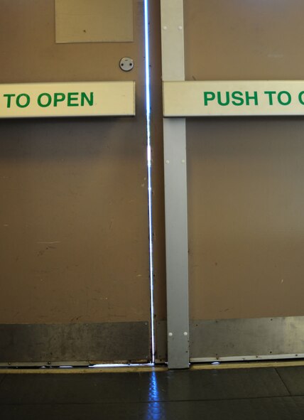 Large gaps between and under doors such as these in Hangar 814 on RAF Mildenhall, England, let in drafts and allow heat to escape. The facility manager in Hangar 814, Staff Sgt. Maurice King, 100th Maintenance Group, is working on a project to install weather-stripping on the doors, which will fill the gaps and keep heat inside the building. This will reduce energy and costs, as radiators will not need to be kept on high and the facility will keep in the heat and stay warmer, providing a more comfortable workplace. (U.S. Air Force photo by Karen Abeyasekere/Released)
