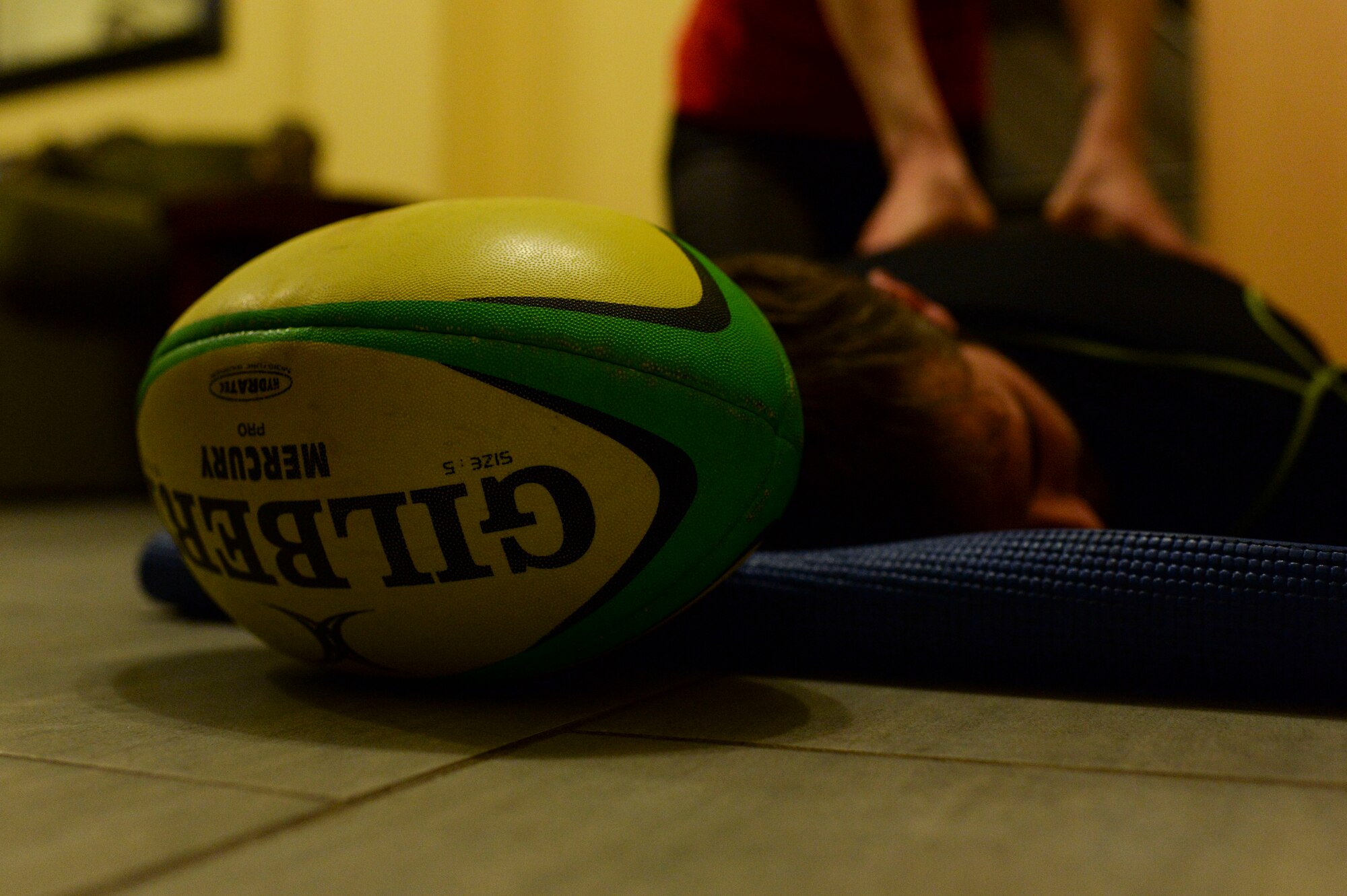 SPANGDAHLEM AIR BASE, Germany--A rugby ball is displayed as Elliot Curtis, a 52nd Force Support Squadron Eifel Arms Inn shuttle driver from Fort Walton Beach, Fla., receives a back massage from his wife Staff Sgt. Charlotte Curtis, a 52nd Judge Advocate paralegal inside their home Oct. 24, 2013. Curtis's wife attends almost every game that he plays in. (U.S. Air Force photo by Senior Airman Rusty Frank/Released)