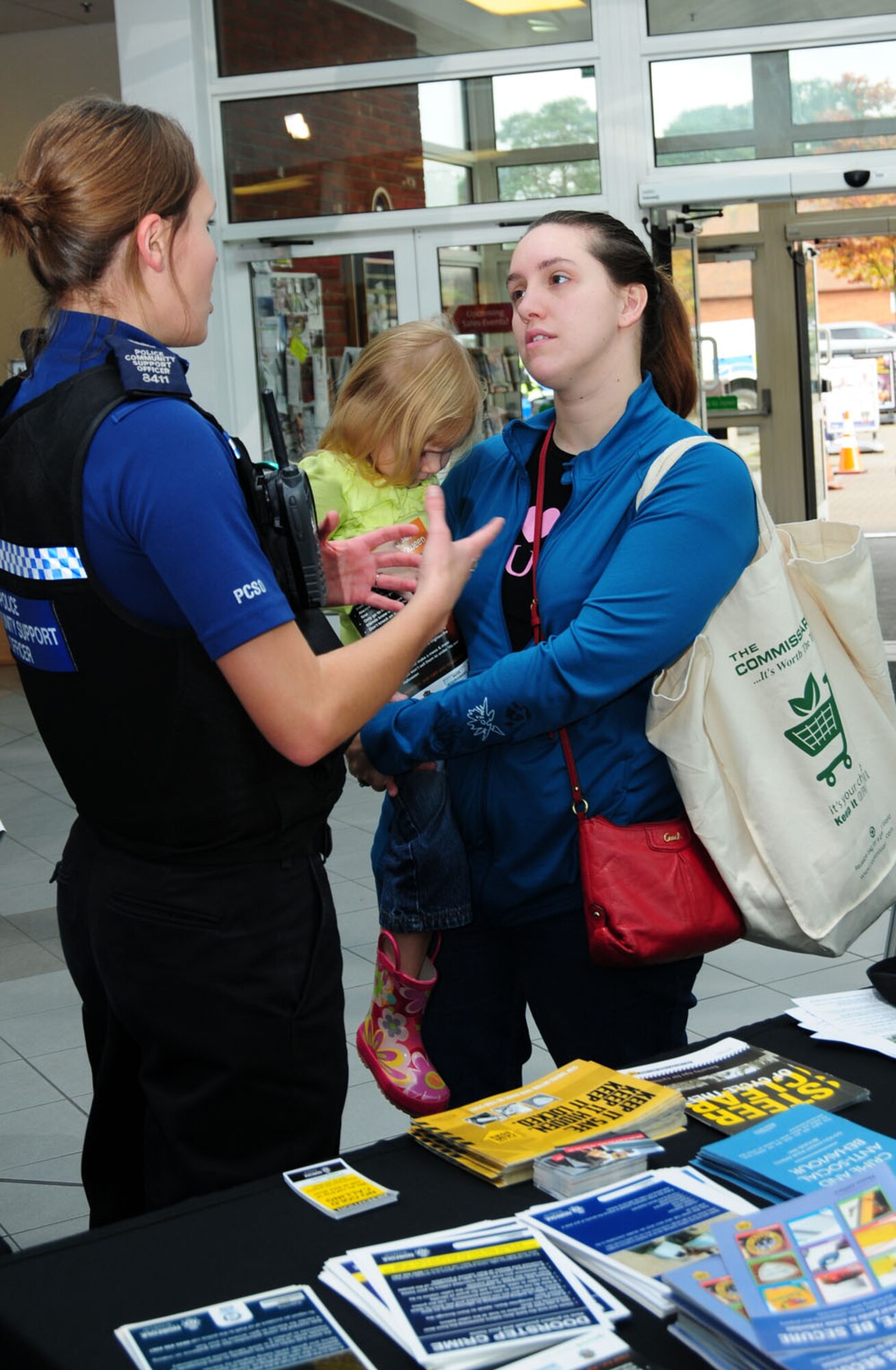 Police Support Community Officer Sara Clipperton, left, Norfolk Police from Downham Market, Norfolk, talks to Amanda Hayes, right, a 100th Logistics Readiness Squadron spouse from Baton Rouge, La., about car crime security Oct. 25, 2013, at the BXtra during the Security Awareness Month wrap-up event on RAF Mildenhall, England. British police from Suffolk, Norfolk and Cambridgeshire, along with Ministry of Defence Police, and Airmen from the 100th Security Forces Squadron and 100th Air Refueling Wing Information Protection and Anti-Terrorism offices set up information booths and spoke with Team Mildenhall members. A military working dog display demonstrated how and why the MWDs are highly valuable assets to both the 100th SFS and RAF Mildenhall. (U.S. Air Force photo by Karen Abeyasekere/Released)