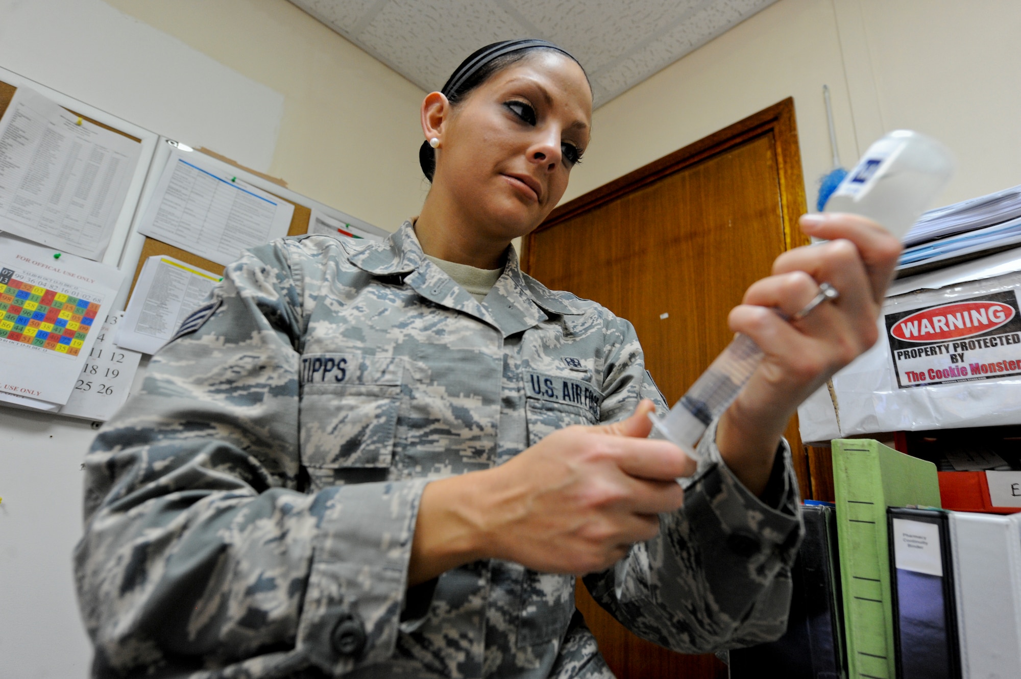 U.S. Air Force Senior Airman Kelly Tipps, 380th Expeditionary Medical Group diagnostic imaging journeyman, extracts medicine from a bottle prior to destroying it at an undisclosed location in Southwest Asia Oct. 16, 2013. Tipps who was a pharmacy technician prior to joining the military volunteers in the pharmacy to help destroy expired medication and prepare over the counter drugs for distribution. Tipps is native to Elderton, Pa., and is deployed from Dyess Air Force Base, Texas. (U.S. Air Force photo by Staff Sgt. Joshua J. Garcia) 
