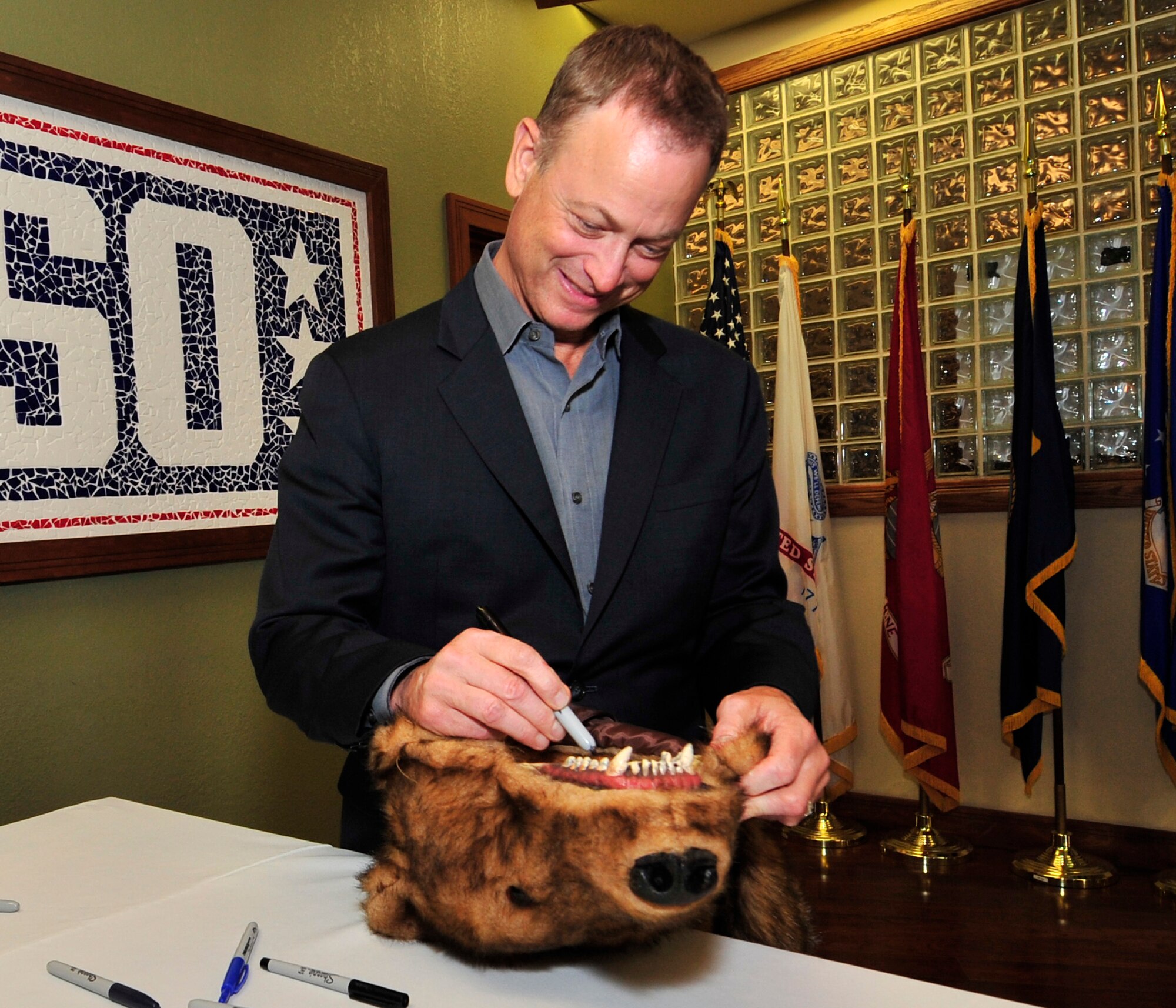 Gary Sinise autographs a bear suit for an Airman Oct. 24, 2013, at the USO on Dover Air Force Base, Del.  Sinise, who has been actively touring with the USO since 2003, was visiting Team Dover to meet and greet Airmen. (U.S. Air Force photo/Tech. Sgt. Chuck Walker ) 
