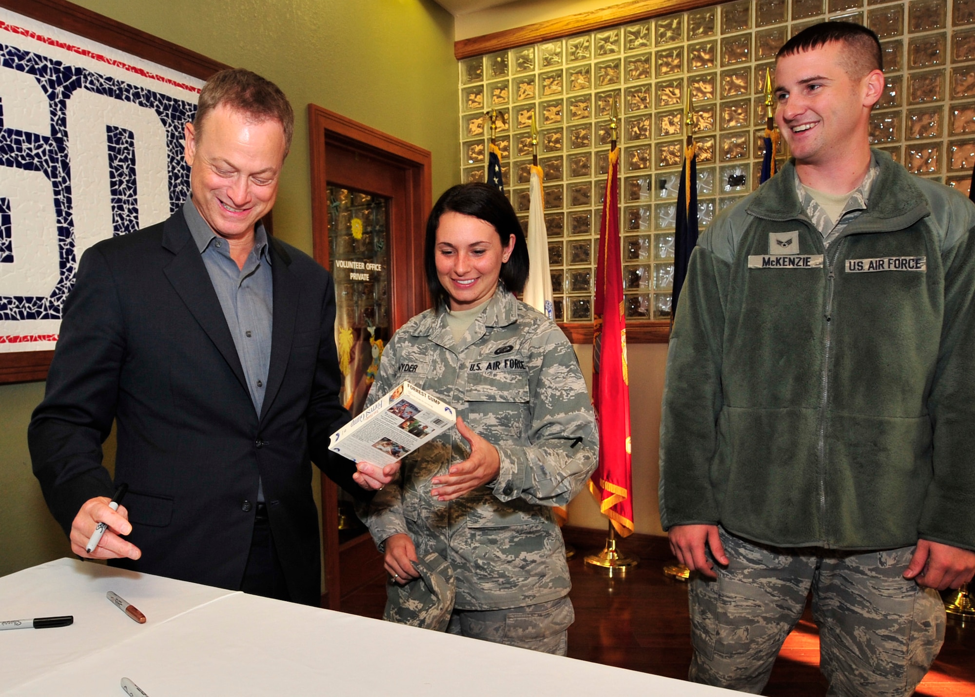 Gary Sinise hands back a VHS copy of “Forrest Gump” he just autographed to Senior Airman Patricia Snyder, 436th Comptroller Squadron assistant quality assurance manager, as Senior Airman Matthew McKenzie, 436th CPTS budget analyst, looks on Oct. 24, 2013, at the USO on Dover Air Force Base, Del. Sinise, who has been actively involved with USO tours since 2003, is best known for his role portraying Lt. Dan Taylor in the movie “Forrest Gump.” (U.S. Air Force photo/Tech. Sgt. Chuck Walker)