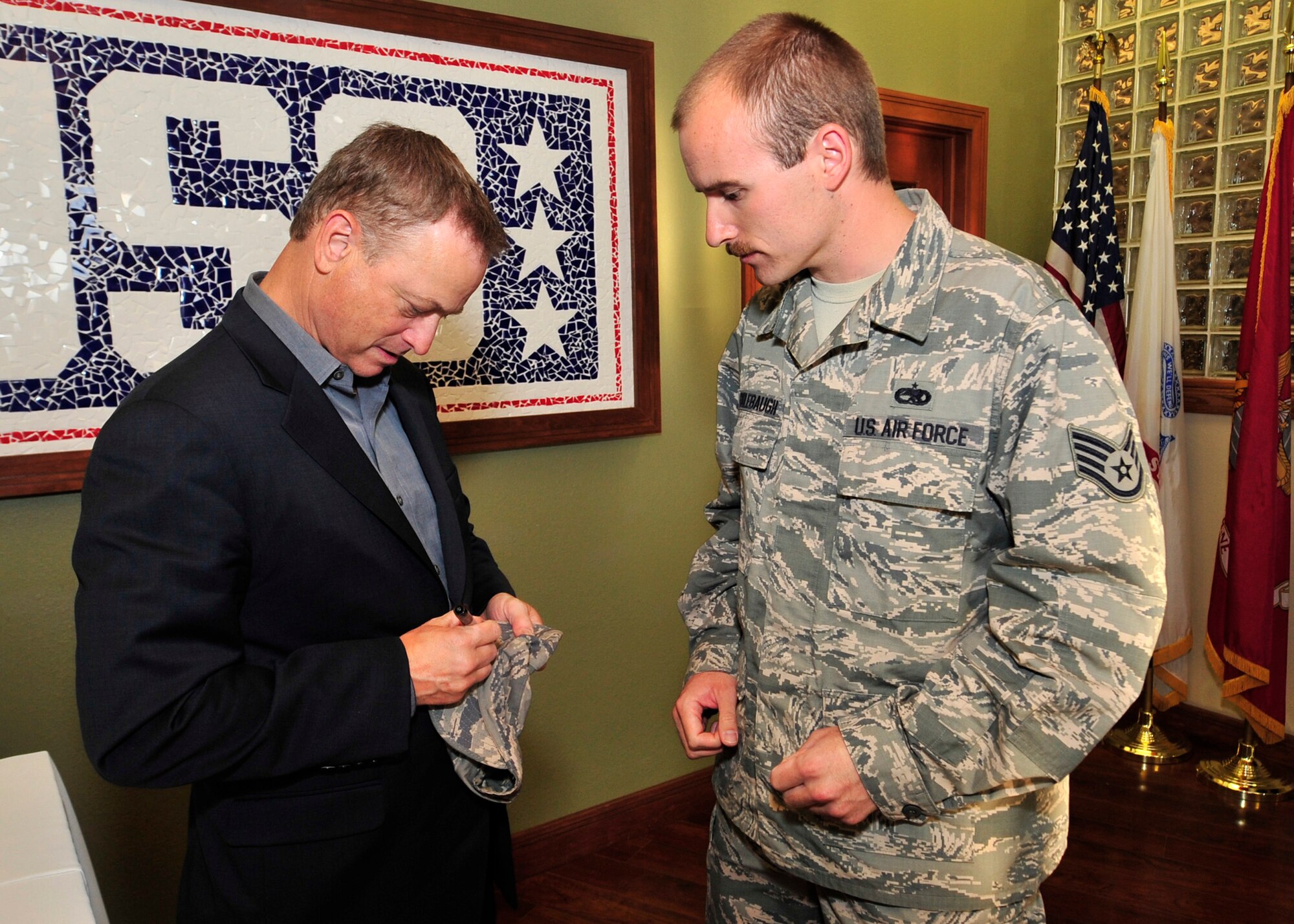 Gary Sinise autographs an ABU hat for Staff Sgt. Donald Cridlebaugh, 436th Maintenance Operations Flight maintenance qualification program instructor, Oct. 24, 2013, at the USO on Dover Air Force Base, Del. Sinise, who has been active with the USO since 2003 visited Team Dover to meet and greet Airmen. (U.S. Air Force photo/Tech. Sgt. Chuck Walker)