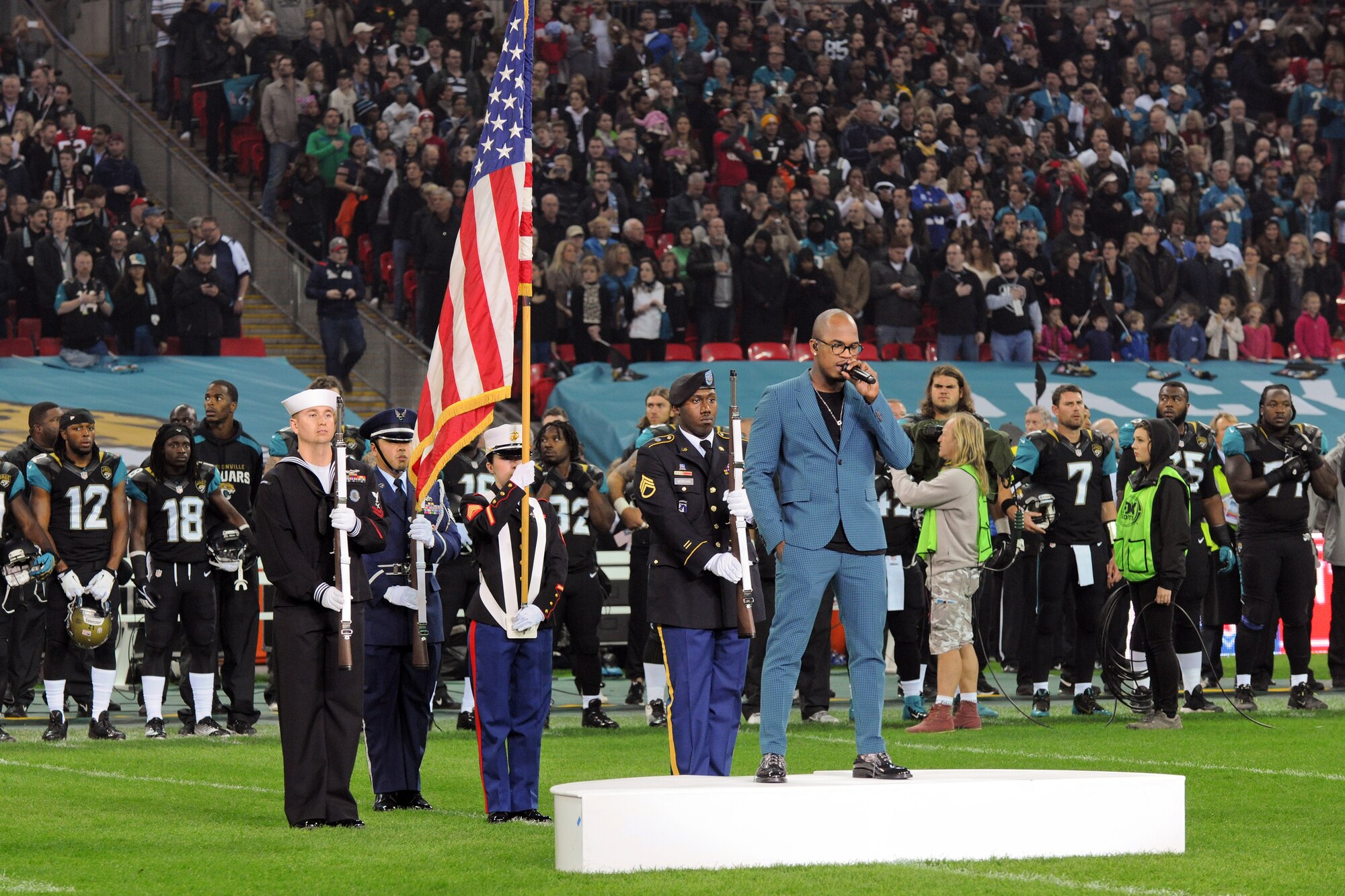 LONDON – (left to right) U.S. Navy Petty Officer 2nd Class Daniel Ayer; U.S. Air Force Staff Sgt. Eldon Pagaragan; U.S. Marine Sgt. Emily Hale; U.S. Army Staff Sgt. Gregory Morgan and Ne-Yo perform during the U.S. national anthem before the start of the 8th International Series NFL game between the San Francisco 49ers and Jacksonville Jaguars in London Oct. 27. The J Joint Service Honor Guard members were from RAF Alconbury and RAF Molesworth. (U.S. Air Force photo by Tech. Sgt. Chrissy Best)