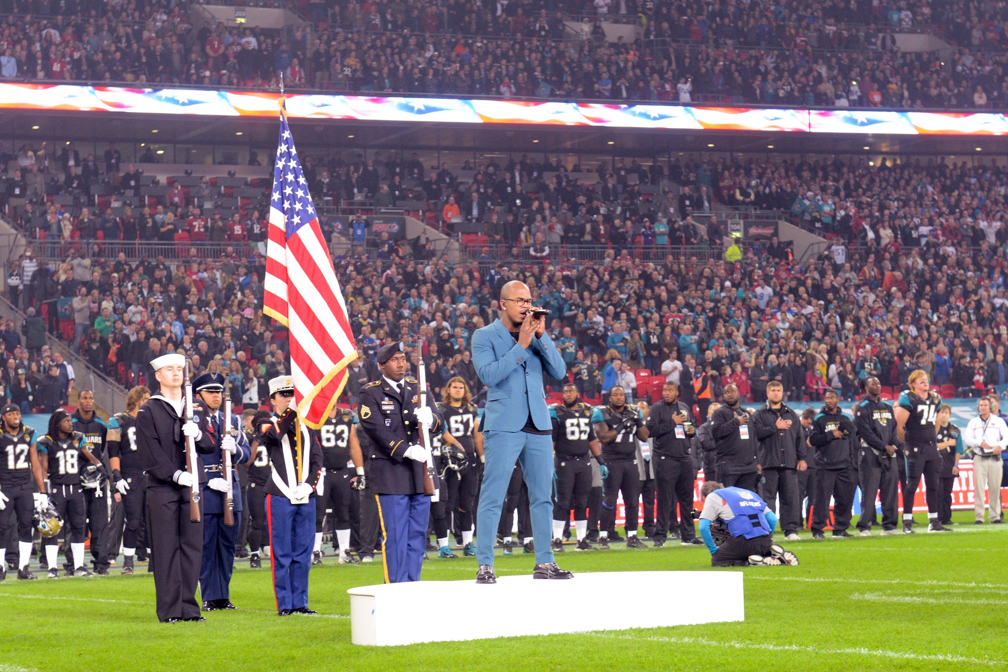 LONDON – (left to right) U.S. Navy Petty Officer 2nd Class Daniel Ayer; U.S. Air Force Staff Sgt. Eldon Pagaragan; U.S. Marine Sgt. Emily Hale; U.S. Army Staff Sgt. Gregory Morgan and Ne-Yo perform during the U.S. national anthem before the start of the 8th International Series NFL game between the San Francisco 49ers and Jacksonville Jaguars in London Oct. 27. The J Joint Service Honor Guard members were from RAF Alconbury and RAF Molesworth. (U.S. Air Force photo by Tech. Sgt. Chrissy Best)