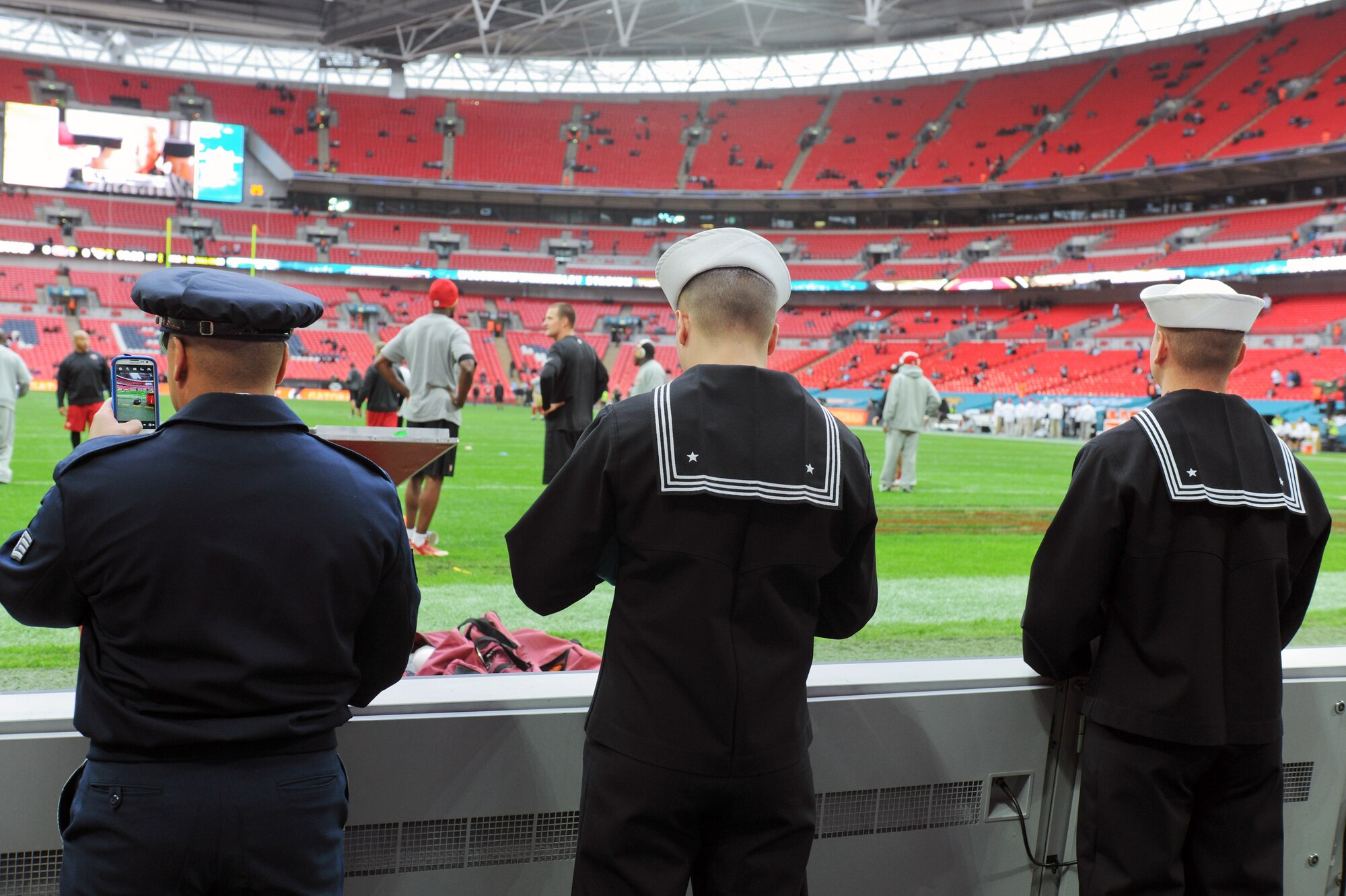 LONDON - Members of the Joint Service Honor Guard take pictures of NFL players warming up before the 8th International Series NFL game between the San Francisco 49ers and Jacksonville Jaguars in London Oct. 27. The Joint Service Honor Guard members posted the colors while Ne-Yo sang the U.S. national anthem. (U.S. Air Force photo by Tech. Sgt. Chrissy Best)