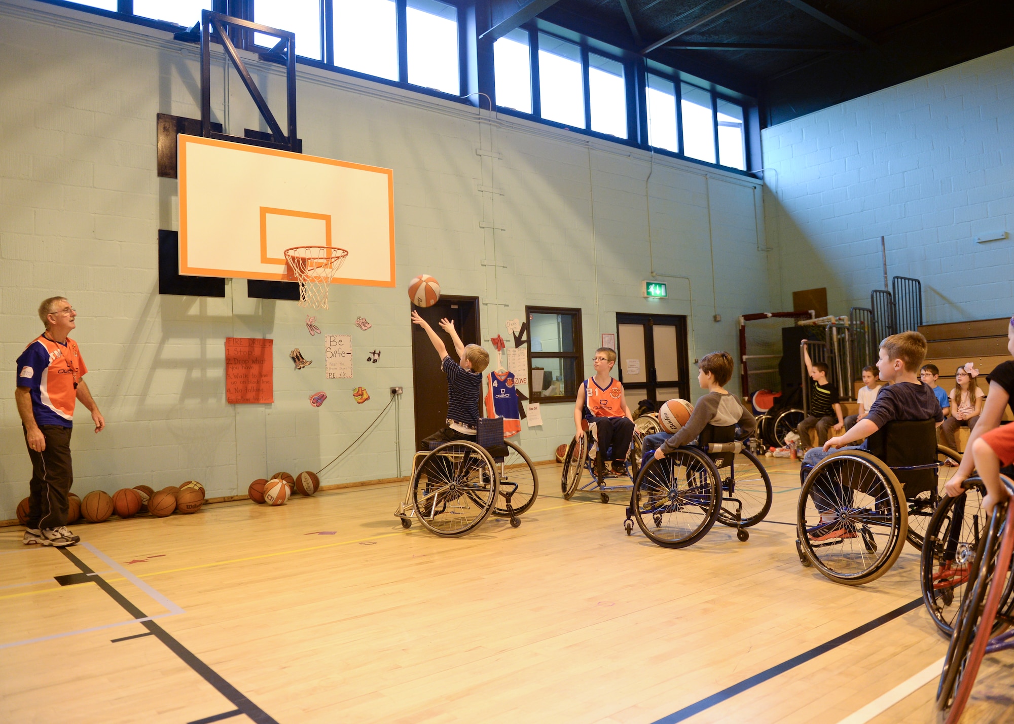 Students at Lakenheath Elementary School get the chance to take shots from specialized wheelchairs during the Bury Bomber visit to Royal Air Force Lakenheath, England, Oct. 22, 2013. During the Bombers’ visit, kids gain knowledge in the sport of wheelchair basketball while also being instilled with respect of persons with disabilities. (U.S. Air Force photo by Airman 1st Class Nigel Sandridge/Released) 