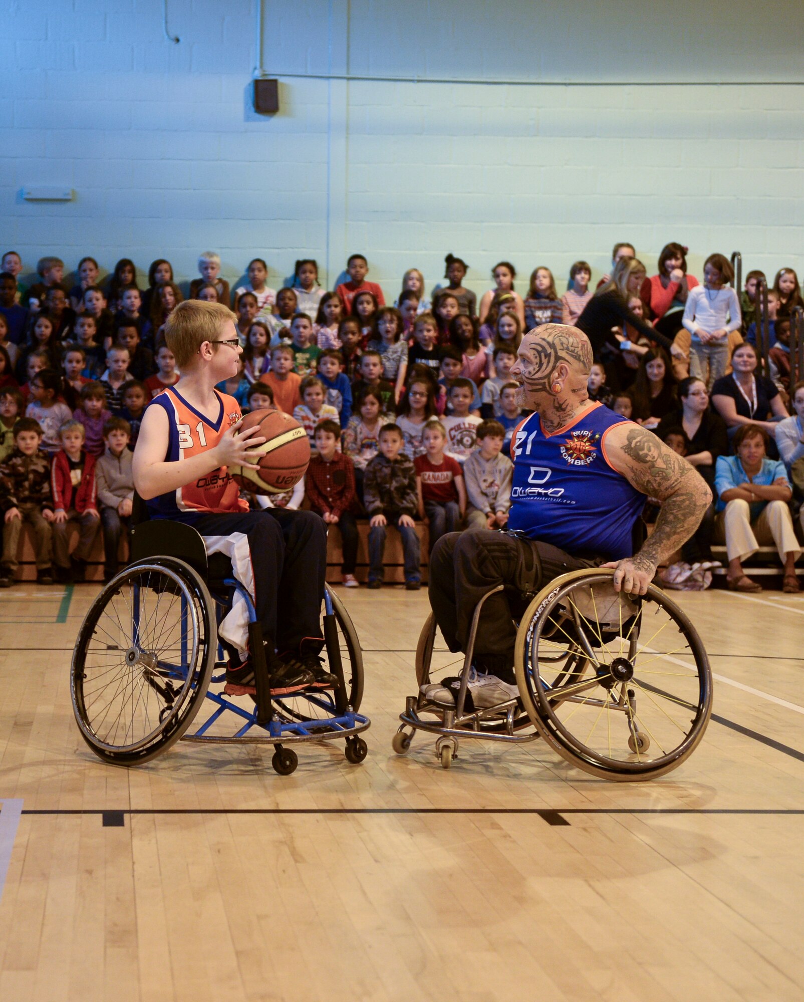 Oliver Guest (left) faces off against his father Paul Guest during the Bury Bombers exhibition match on Royal Air Force Lakenheath, England, Oct. 22, 2013. During the Bombers’ visit, kids gain knowledge in the sport of wheelchair basketball while also being instilled with respect of persons with disabilities. (U.S. Air Force photo by Airman 1st Class Nigel Sandridge/Released) 