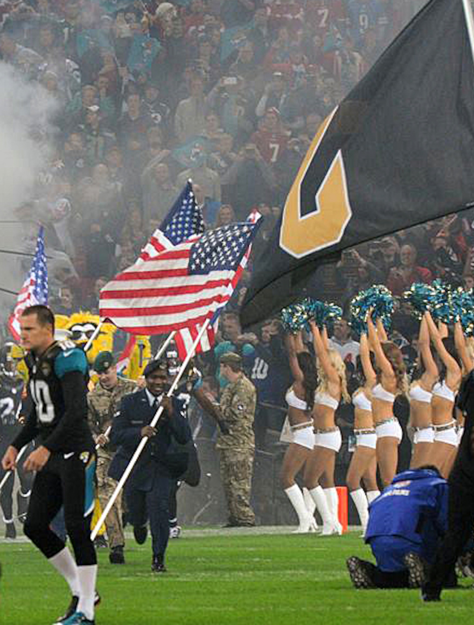 U.S. Air Force Airman 1st Class James Taylor, center, 100th Security Forces Squadron patrolman, leads prior the National Football League’s Jacksonville Jaguars onto the field Oct. 27, 2013, at Wembley Stadium in London, England. Taylor's leadership presented him with this surprise opportunity to represent the U.S. Air Force and his hometown NFL team.  The NFL gave Taylor and U.S. Air Force Airman Sara V. Summers, 48th Security Forces Squadron patrolman from RAF Lakenheath, the opportunity to lead rival football teams onto the field The 501st Combat Support Wing's honor guard team presented the colors while the National Anthem played prior to the start of the game. (U.S. Air Force photo by Tech. Sgt. Chrissy Best/Released)