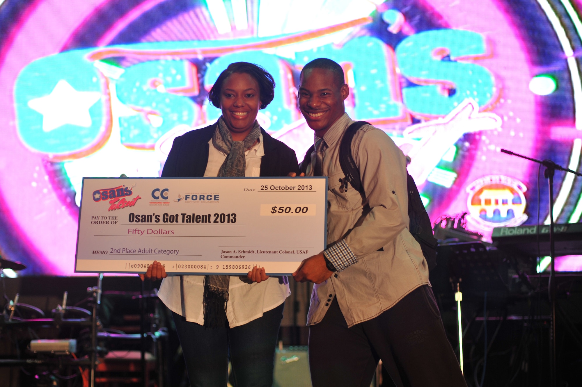Airman 1st Class Aaron Blaylock, 51st Operations Support Squadron aircrew flight equipment apprentice is presented with the second place prize for adults category at the ‘Osan’s got talent’ talent show at Osan Air Base Republic of Korea, Oct. 26, 2013. Contestants ranged in age from four to 40, representing the entire community. (U.S. Air Force photo/Staff Sgt. Emerson Nuñez)