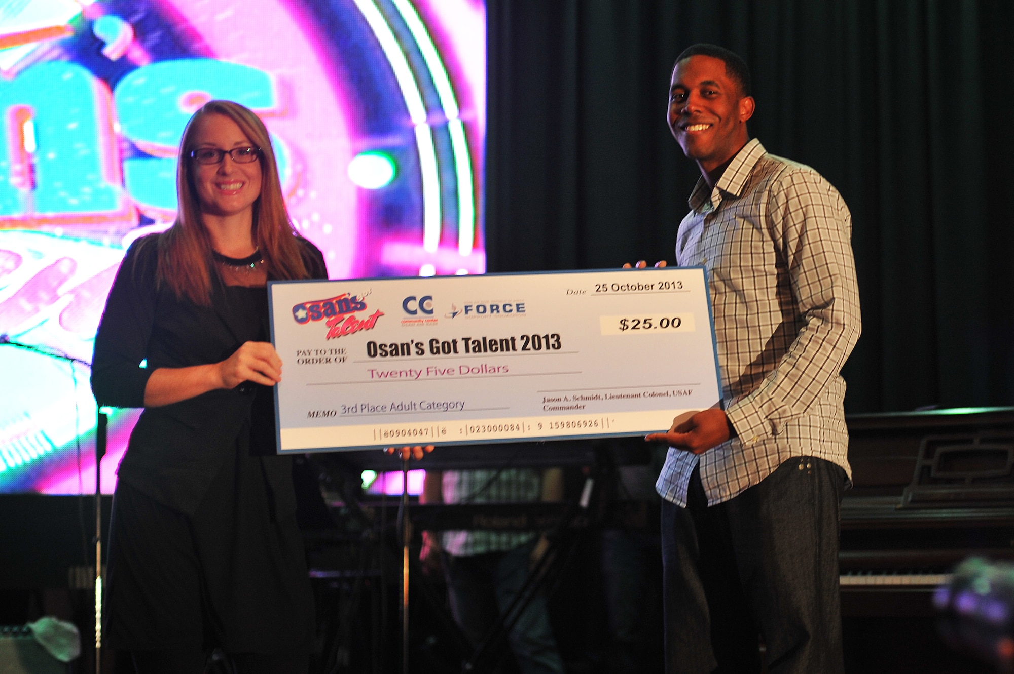 Capt. Jahmil Edwards, right, Air Force Intelligence, Surveillance and Reconnaissance Agency, poses with the third place prize for the adult’s category at the ‘Osan’s got talent’ contest at Osan Air Base Republic of Korea, Oct. 26, 2013. More than 350 family and friends cheered on their favorite contestants as they performed magic acts, sang, and danced the night away. (U.S. Air Force photo/Staff Sgt. Emerson Nuñez)