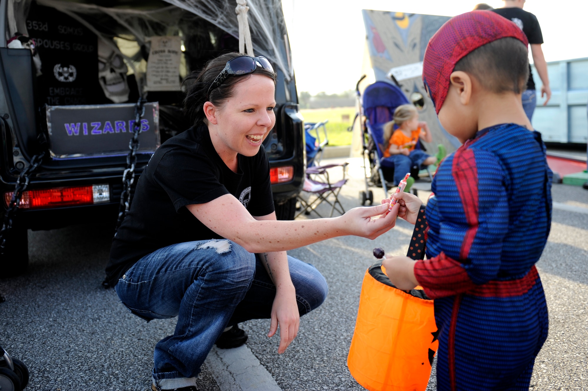 Virginia Kemp, 353rd Special Operations Maintenance Squadron key spouse, passes out candy during the trunk-or-treat portion of the 2013 Fall Harvest Festival on Kadena Air Base, Japan, Oct. 26, 2013. Led by the 18th Force Support Squadron Airman and Family Services Flight and the Airman and Family Readiness Center, the event included food and games as well as pie-eating and costume contests. (U.S. Air Force photo by Senior Airman Maeson L. Elleman)
