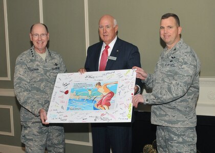 OFFUTT AIR FORCE BASE, Neb. -- Gen. C. Robert Kehler, commander of U.S. Strategic Command, and Col. Gregory Guillot, 55th Wing commander, present a thank you card to Ken Stinson, Strategic Command Consultation (SCC)\r\nCommittee chairman, at the Patriot Club on Oct. 25, at Offutt Air Force Base, Neb. The card was signed by members of the military and their families to express their appreciation to the SCC members for donating nearly $100,000 to the\r\nbase to reopen the pool this past summer when budget cuts threatened to close it. (Photo by Steve Cunningham)