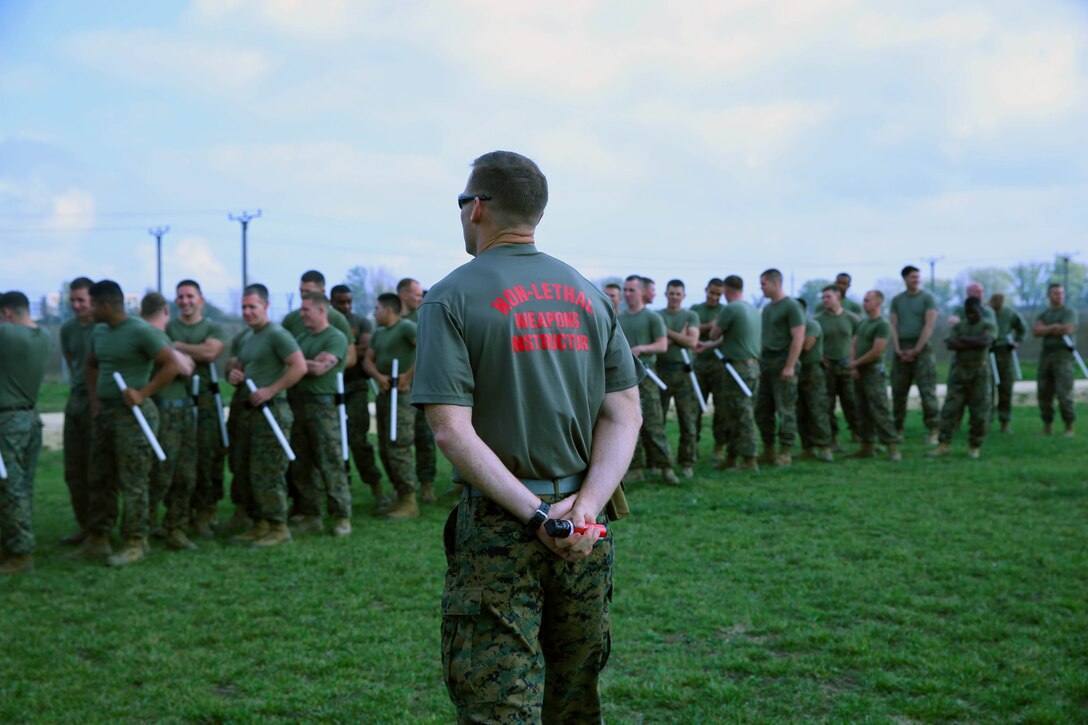 Chief Warrant Officer Mike Haskett, a non-lethal weapons instructor with Black Sea Rotational Force 14, stands in front of Marines and Sailors with Black Sea Rotational Force 14 before they begin the OC level one qualification course at Mihail Kogalniceanu, Romania, Oct. 24, 2013. Non-lethal weapons are specifically employed in order to incapacitate people or equipment with minimal casualties.  This resource provides an advantage in issues of riot control, crisis management and detainee handling.