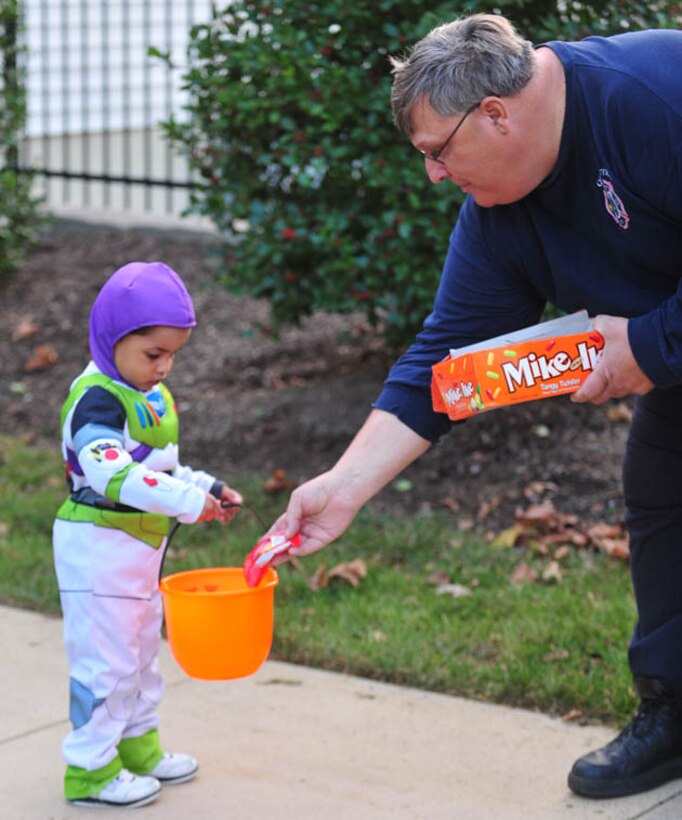 Buzzlightyear, also known as Jordan, a 3-year-old child, recieves candy from fire inspector, Jimmy Raines while trick-or-treating. MCB Quantico fire station and police officers were patrolling around base housing to make sure all is safe and sound on Halloween night.

