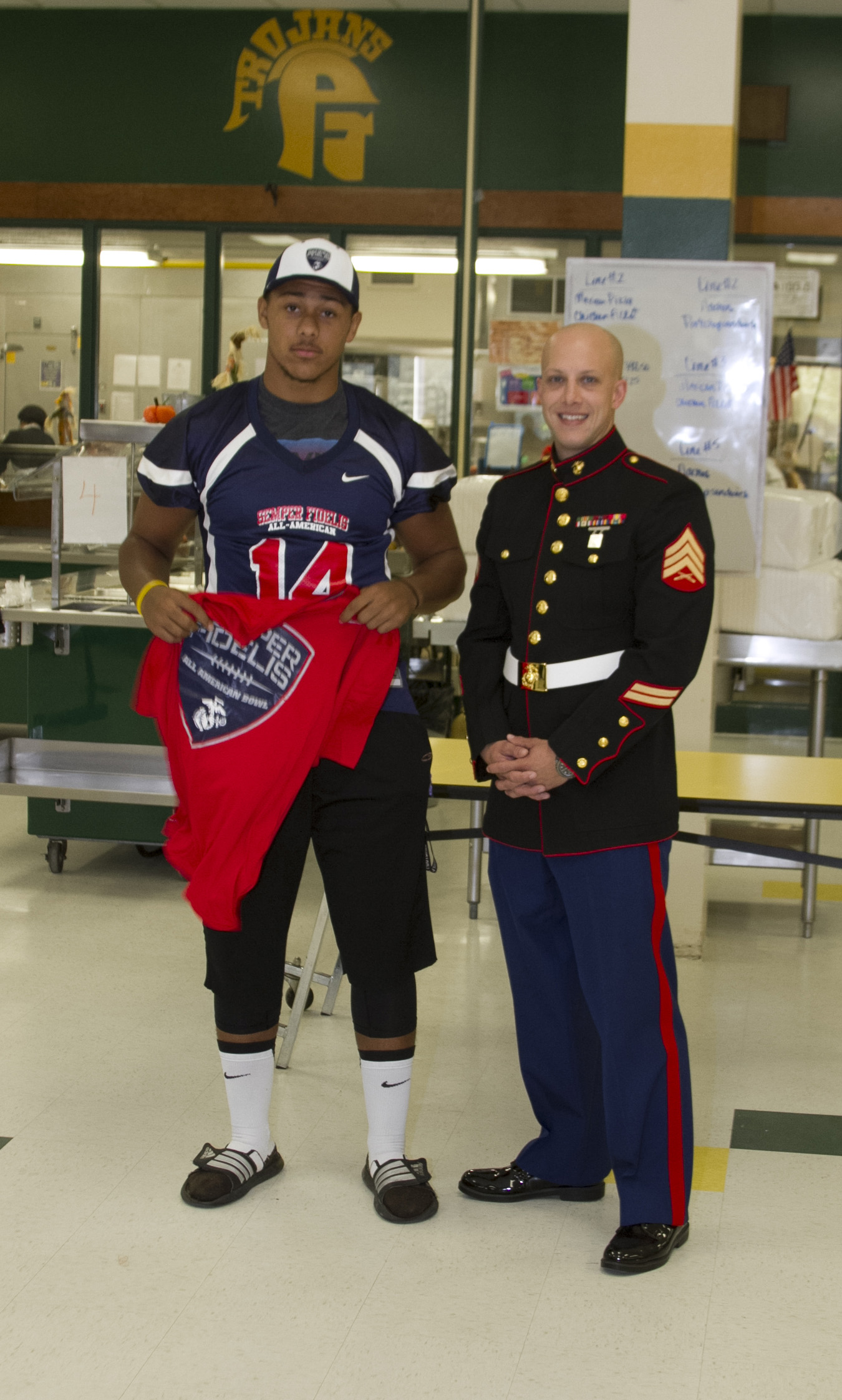 U.S. Marine Corps Sgt. Matthew Pruitt, a recruiter with Marine Corps Recruiting Sub Station Fayetteville, poses for a picture with Harold Landry, a defensive end for the Pine Forest High School football team, during his Semper Fidelis All-American Bowl jersey presentation at Pine Forest High School in Fayetteville, N.C., Oct. 23, 2013. Landry was selected to play in the bowl for his skill as a defensive end, his academics and his leadership ability.  The Semper Fidelis All-American Bowl allows the Marine Corps to purposefully engage with well-rounded student athletes to share leadership lessons that will enable future success. It will be played on Jan. 5, 2014, in Carson City, Calif., and will be broadcast on Fox Sports 1. (U.S. Marine Corps photo by Sgt. Dwight A. Henderson/Released) 