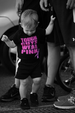 A young participant stands behind IronWorks Gym aboard Marine Corps Air Station Iwakuni, Japan, sporting a “tough guys wear pink” shirt after the Breast Cancer Awareness 5k run/walk on Oct. 12, 2013. “Tough guys wear pink” was a popular motto for male participants during the 5k. (Photo Illustration by Pfc. Alissa P. Schuning)