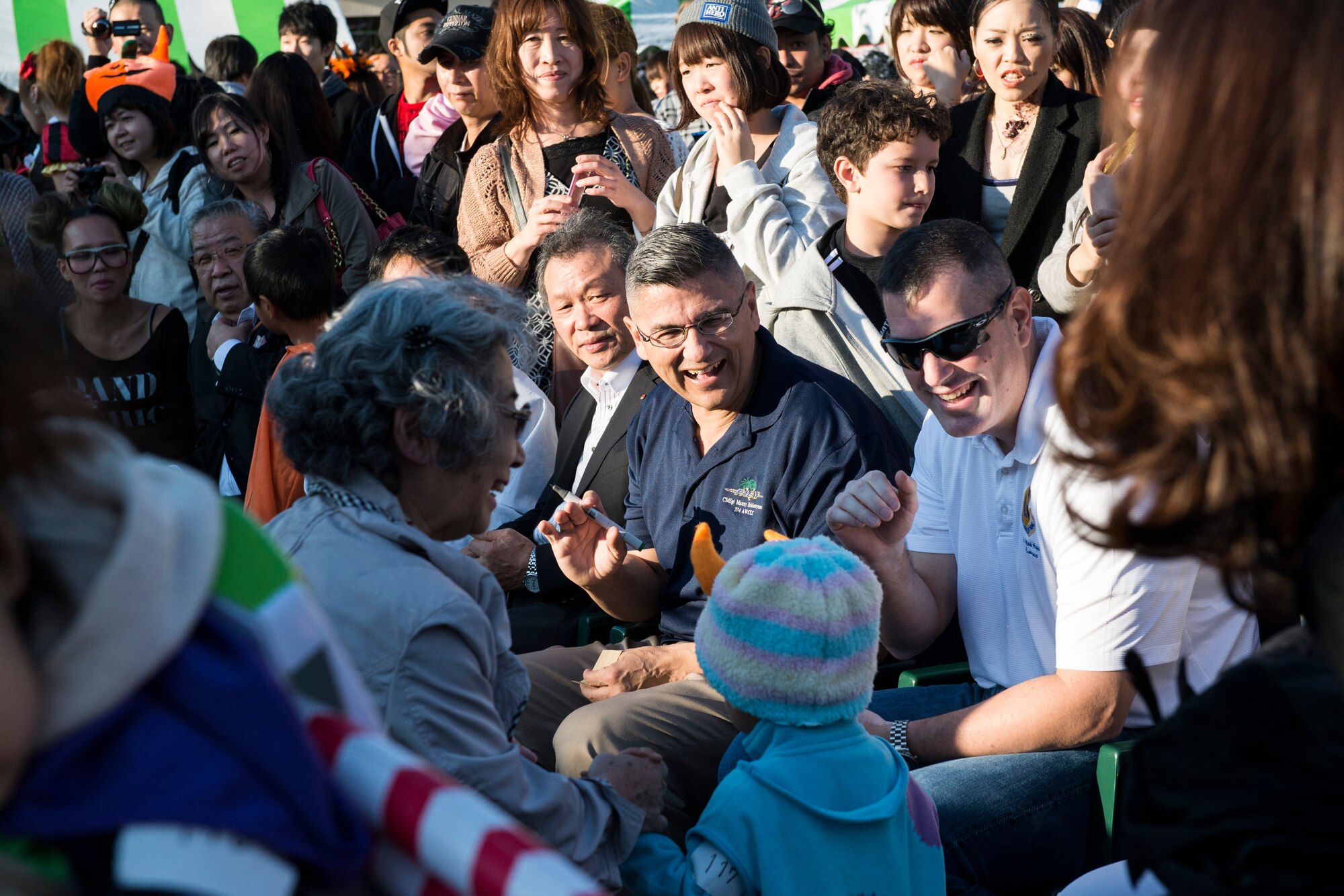 Col. Mark August, 374th Airlift Wing commander, and Chief Master Sgt. Manuel Roblesreynoso, 374 AW command chief, greet Japanese costume contestants at Fussa, Japan, Oct. 27, 2013. The costume contest was part of this year’s Halloween festival just outside the gates of Yokota Air Base, Japan. (U.S. Air Force photo by Senior Airman Cody H. Ramirez)