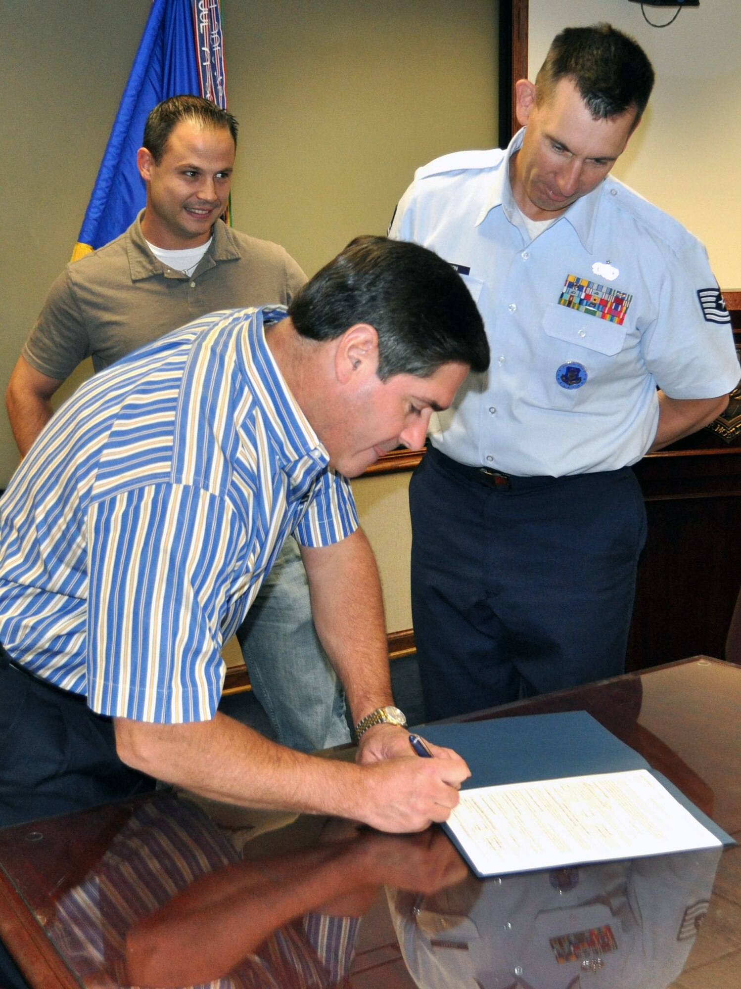 TRAVIS AIR FORCE BASE, Calif. -- Retired Col. Barrett Broussard signs the order of enlistment for Joshua S. Millay, one of the newest recruits for the 349th AMW. Millay, prior service in the Navy, is entering as a staff sergeant, and will join the 312th AS as a flight engineer. Broussard retired as Vice Commander of the Reserve wing here in June 2011. (U.S. Air Force photo/Ellen Hatfield)