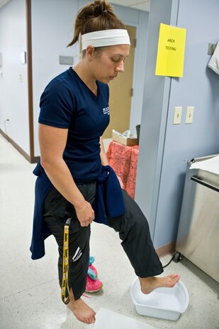 Kelley Welchert, 99th Aerospace Medicine Squadron health and fitness specialist, takes a foot arch test during the second annual occupational and physical therapy open house at the Mike O'Callaghan Federal Medical Center Oct. 29, 2013, at Nellis Air Force Base, Nev. At this station, participants were able to find out what type of arch their feet have. (U.S. Air Force photo by Senior Airman Matthew Lancaster)