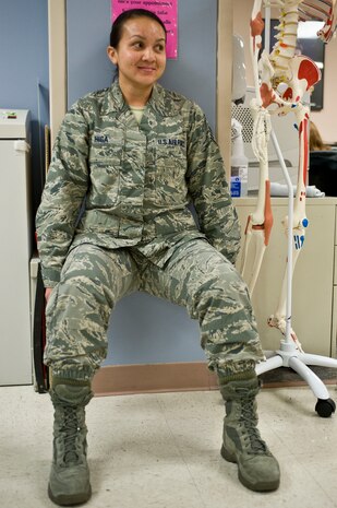 Staff Sgt. Sheena Higa, 99th Surgical Operations Squadron medical administration technician, performs a wall squat during the second annual occupational and physical therapy open house at the Mike O'Callaghan Federal Medical Center Oct. 29, 2013, at Nellis Air Force Base, Nev. Participants were timed to see who could hold a wall squat the longest at this station. The winner of the event received a gift card. (U.S. Air Force photo by Senior Airman Matthew Lancaster)
