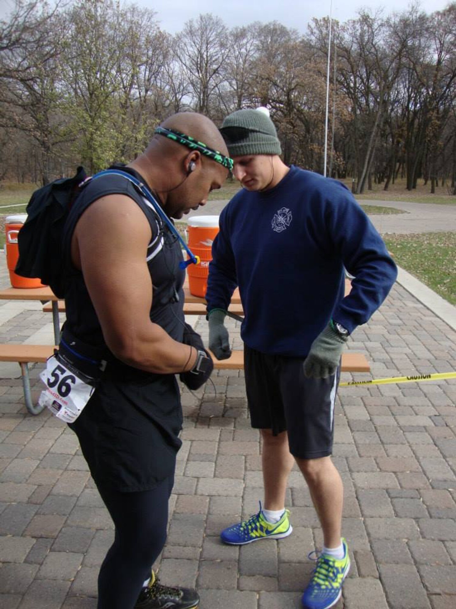 Tech. Sgt. Byron Ball, hands off the belt with the tag number to Staff Sgt. Shane Holland during the Extreme North Dakota's Terrifying Run Amongst Innumerable Lost Souls, held Oct. 27, 2013, at Turtle River State Park in Arvilla, N.D. The two NCOs were part of a four-person team that placed third overall in the relay team category of the endurance race and called themselves the Burninators. (Courtesy photo)